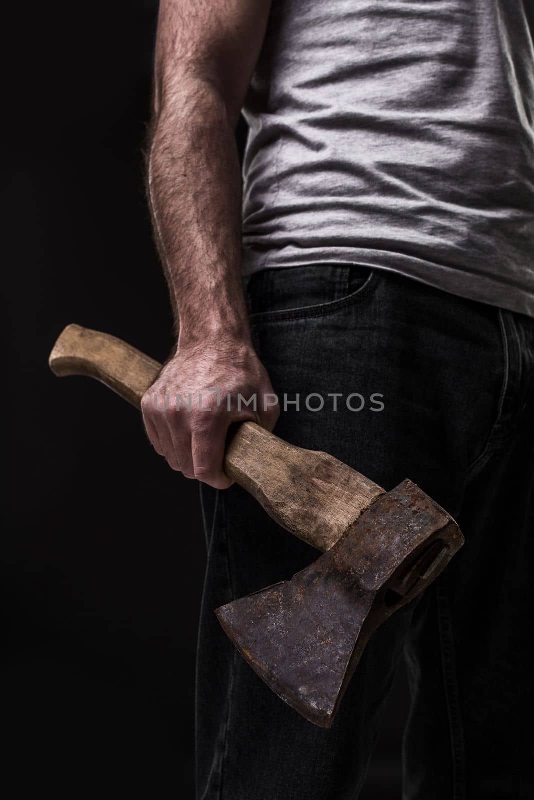 A man holds an ax in his hands against on black background. Criminal