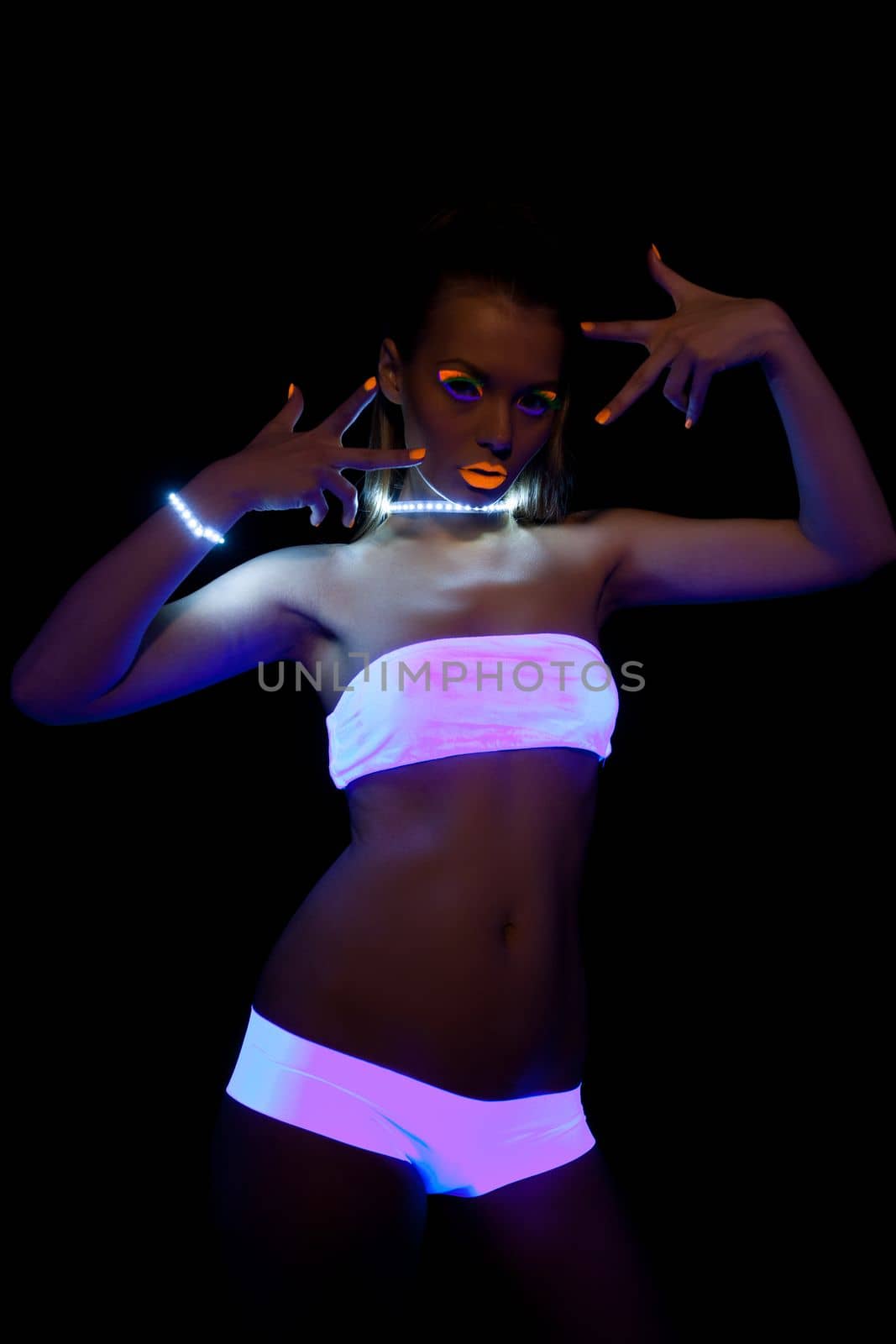 sexy girl with glow make-up dance in ultraviolet light