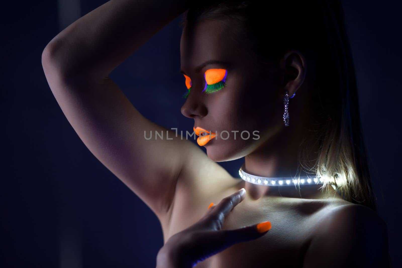 Beauty woman dance with glow make-up under ultraviolet light