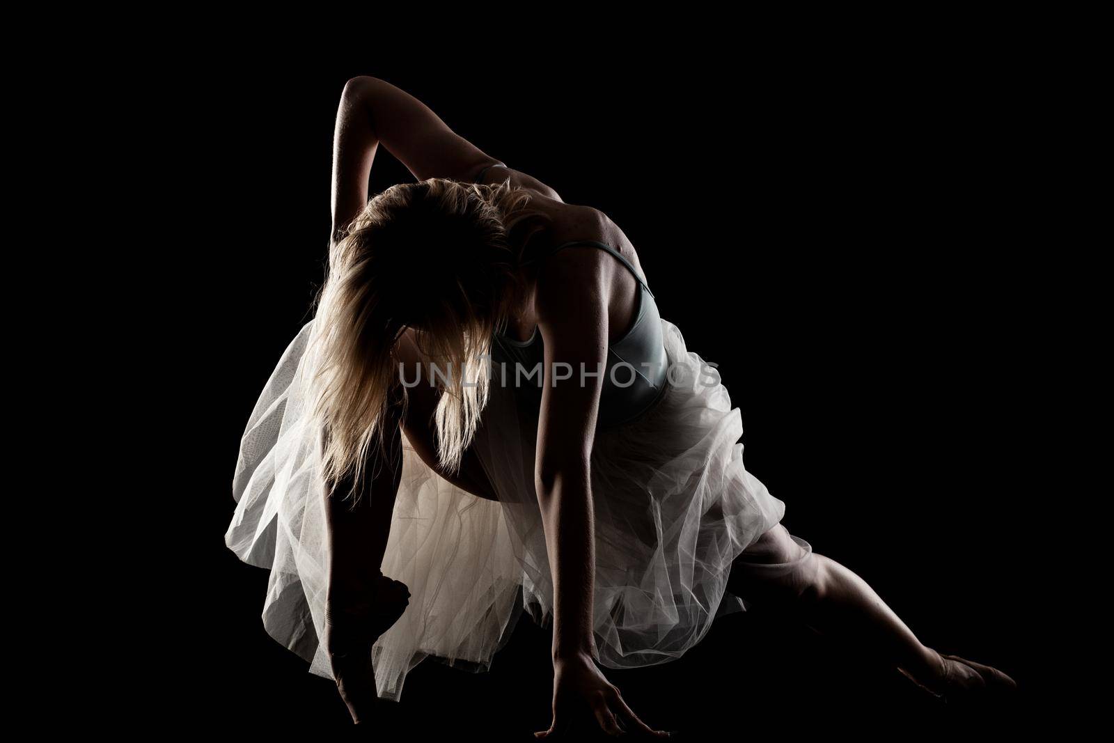 ballerina with a white dress and black top posing on black background. side lit silhouette. by kokimk