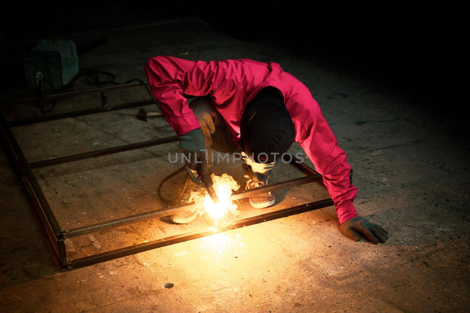 Welder used grinding stone on steel in factory with sparks, Welding process at the industrial workshop, hands with instrument in frame.