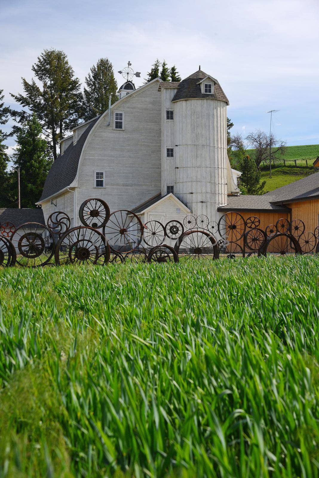 a barn with wheel fence by porbital