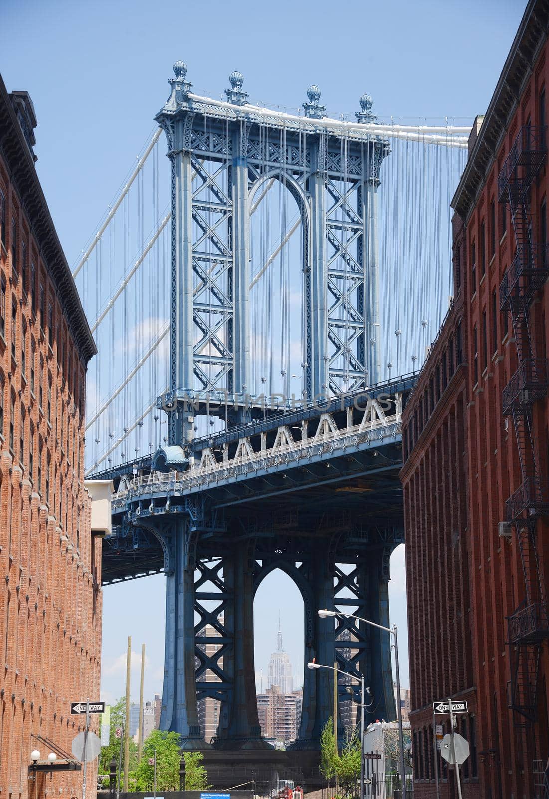 east tower of manhattan bridge framed with old building in brooklyn