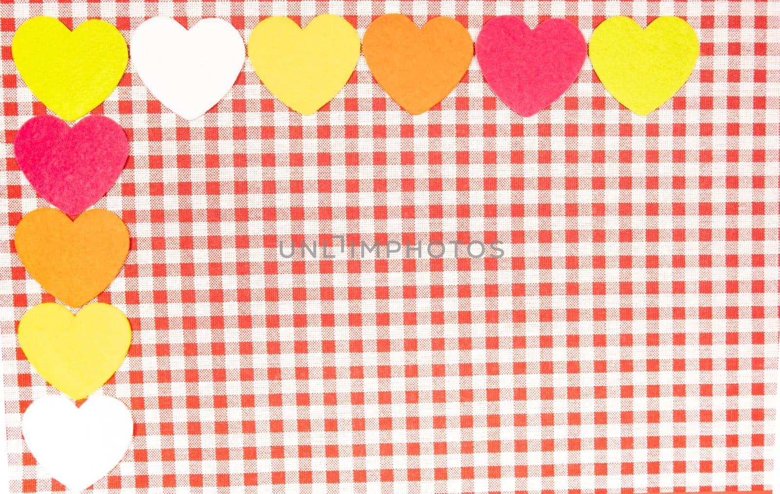 background with red and white Vichy fabric for Valentine's Day with pink, orange, yellow and white hearts. valentines day concept.