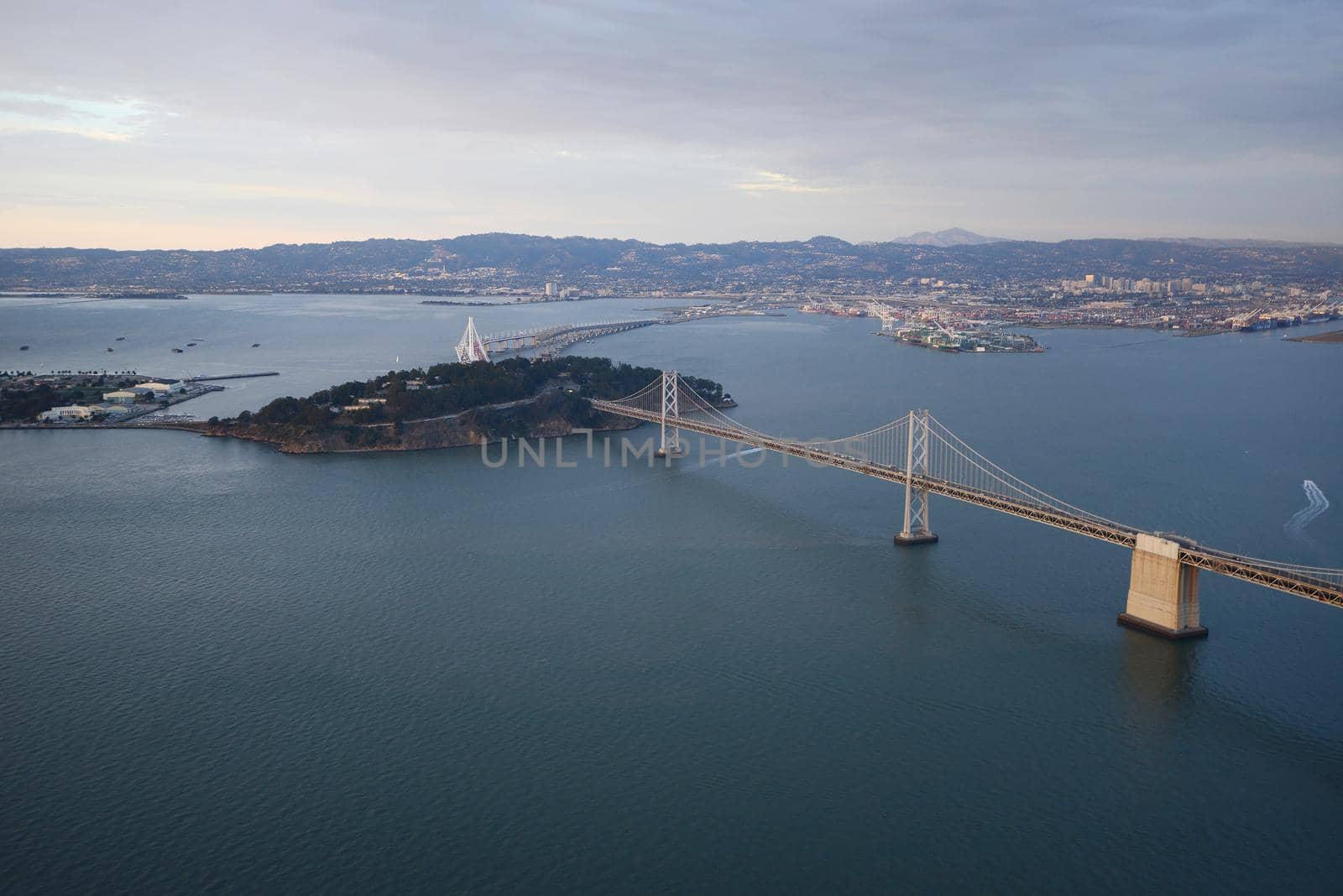 an aerial view of bay bridge near san francisco downtown during sunset, taken from a helicopter 