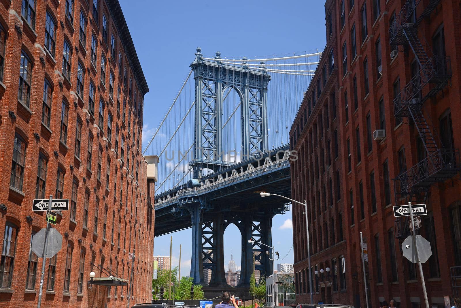 east tower of manhattan bridge framed with old building in brooklyn