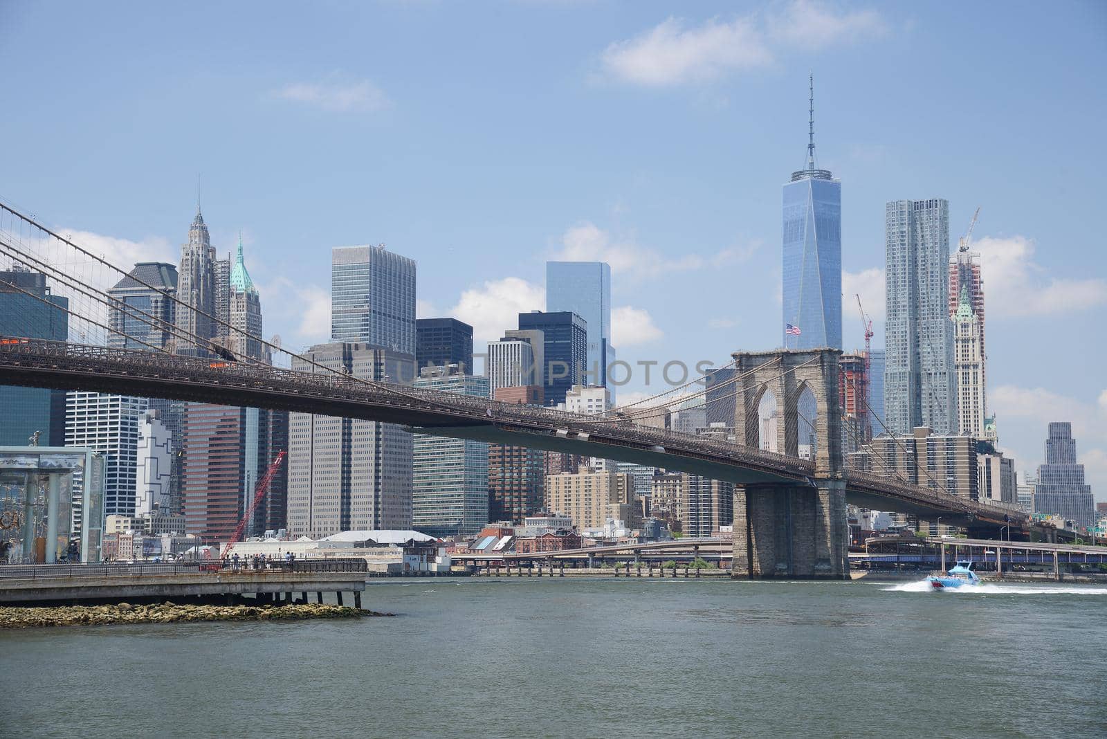 brooklyn bridge under a blue sky with downtown new york city as a background