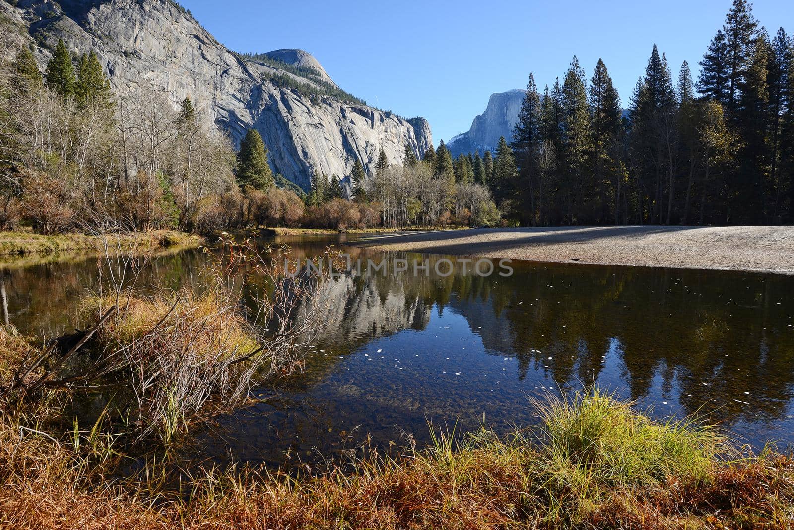 a reflection of half dome of yosemite over merced river