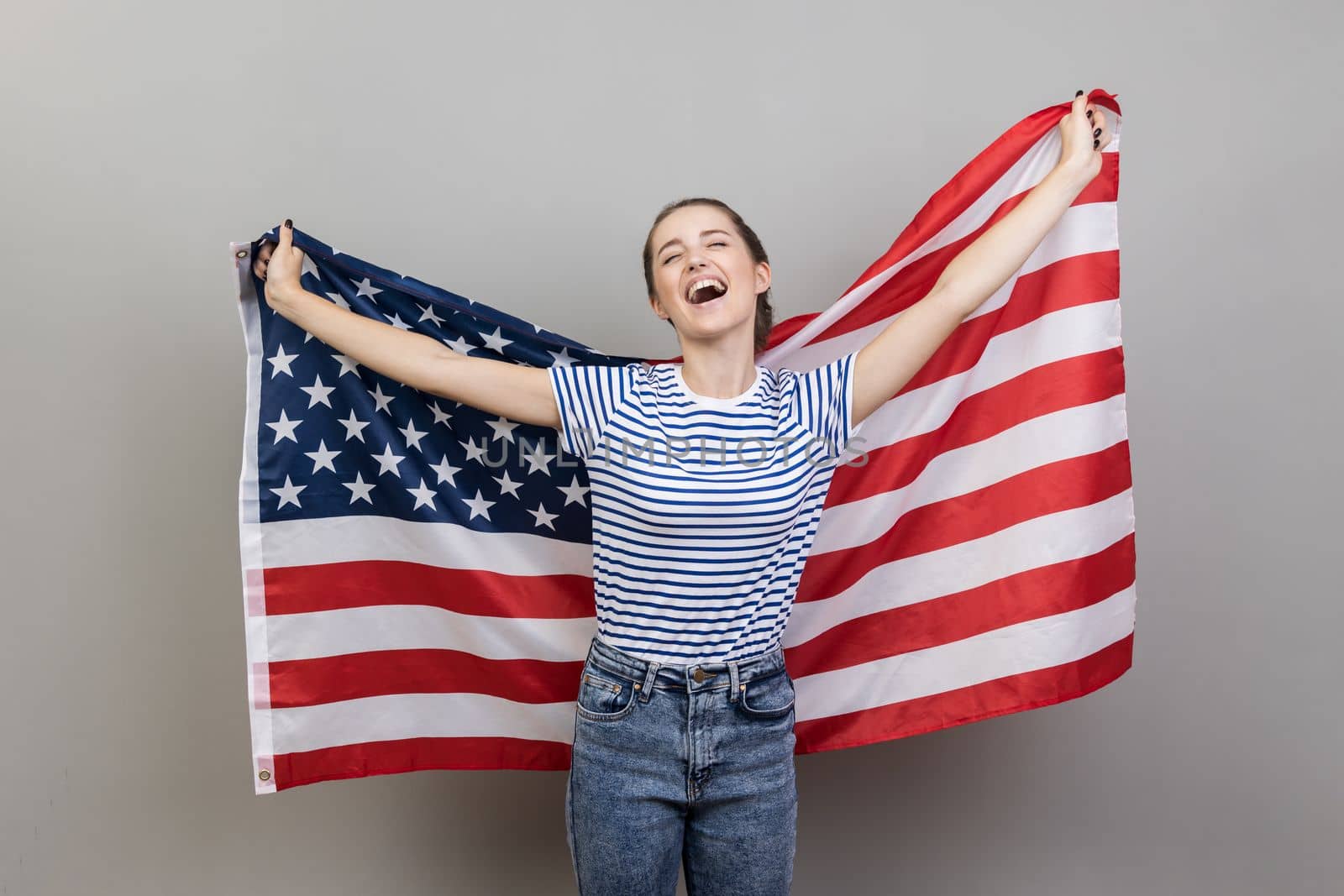 Woman holding big american flag, expressing happiness, screaming happily, rejoicing. by Khosro1