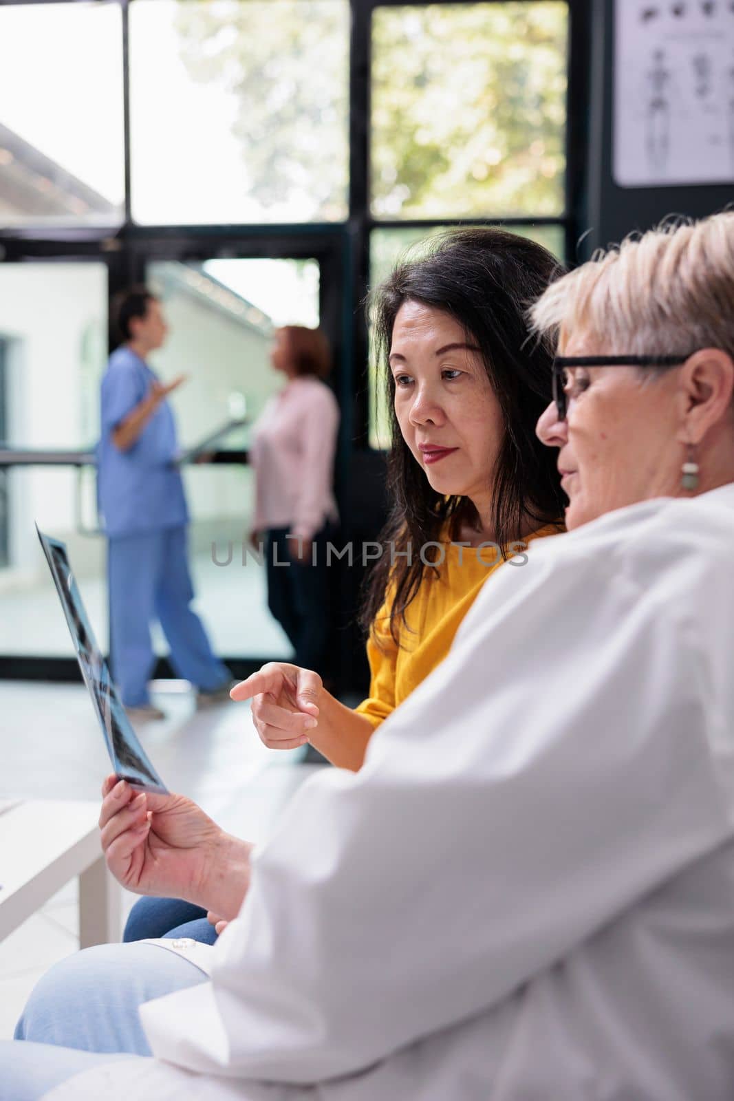 Senior physician doctor looking at radiography exam scan by DCStudio