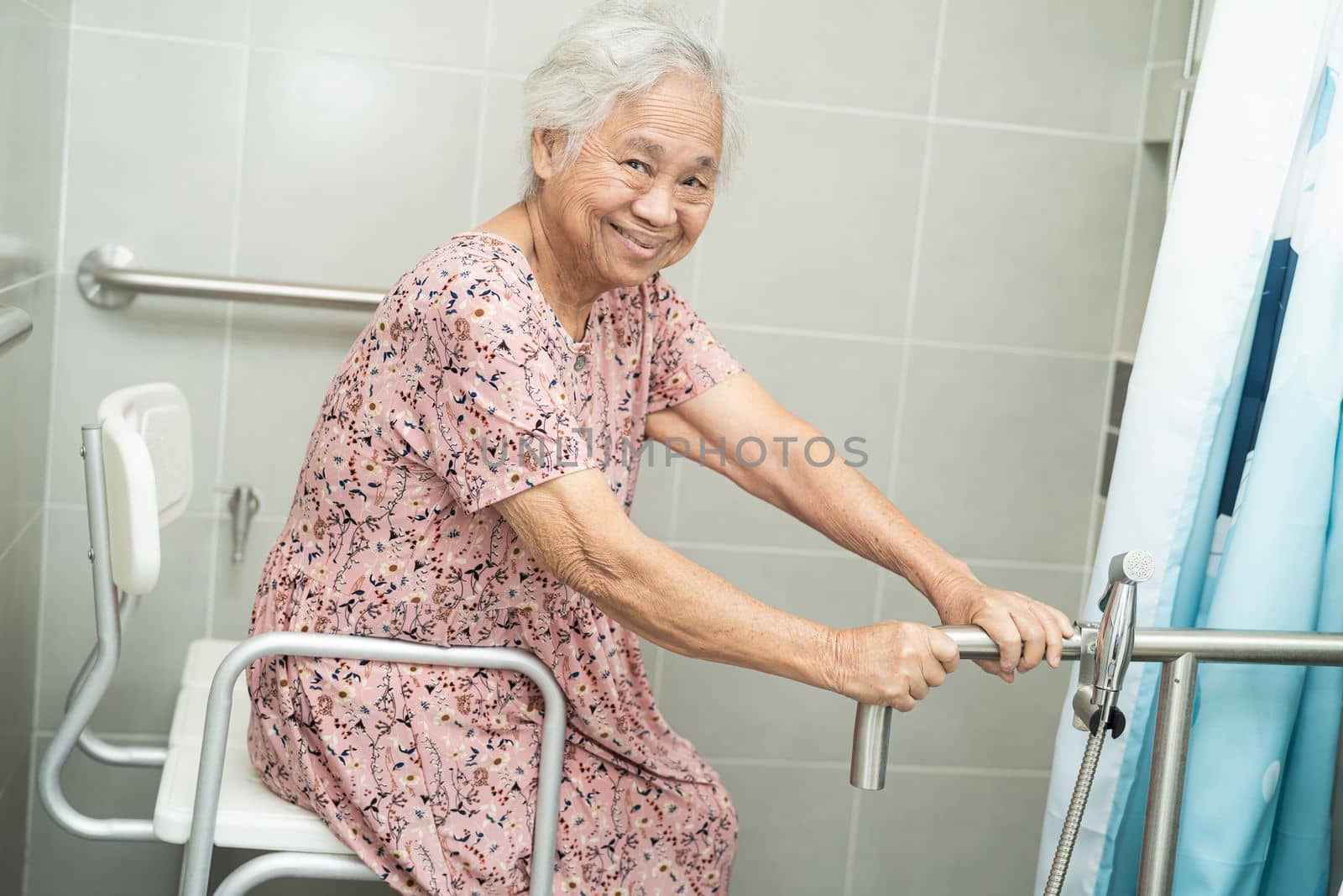 Asian elderly woman patient use toilet bathroom handle security in nursing hospital ward, healthy strong medical concept.