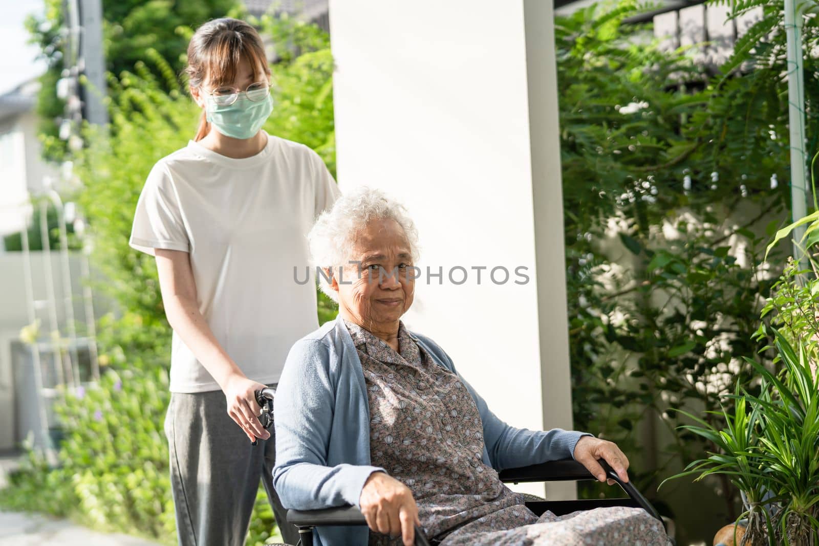 Caregiver help and care Asian senior or elderly old lady woman patient sitting on wheelchair to ramp in nursing hospital, healthy strong medical concept.