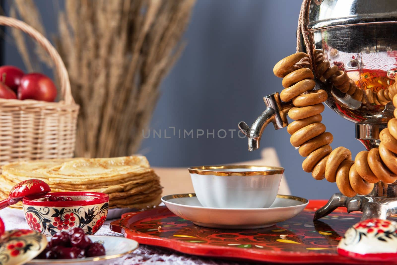 Pancakes with berries and sour cream, samovar and drying on the table. Shrovetide Maslenitsa festival concept.