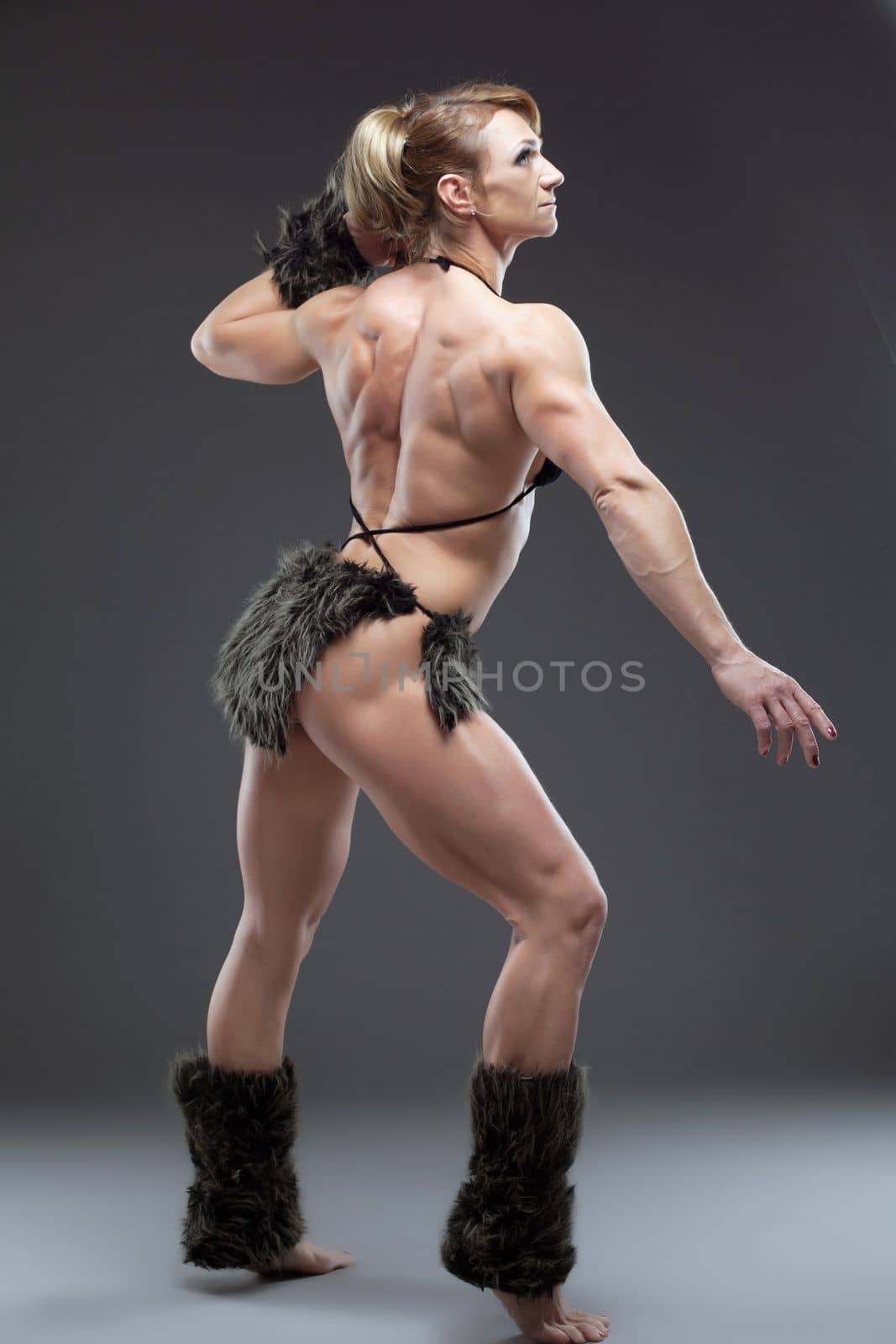 Woman body builder posing in studio by rivertime