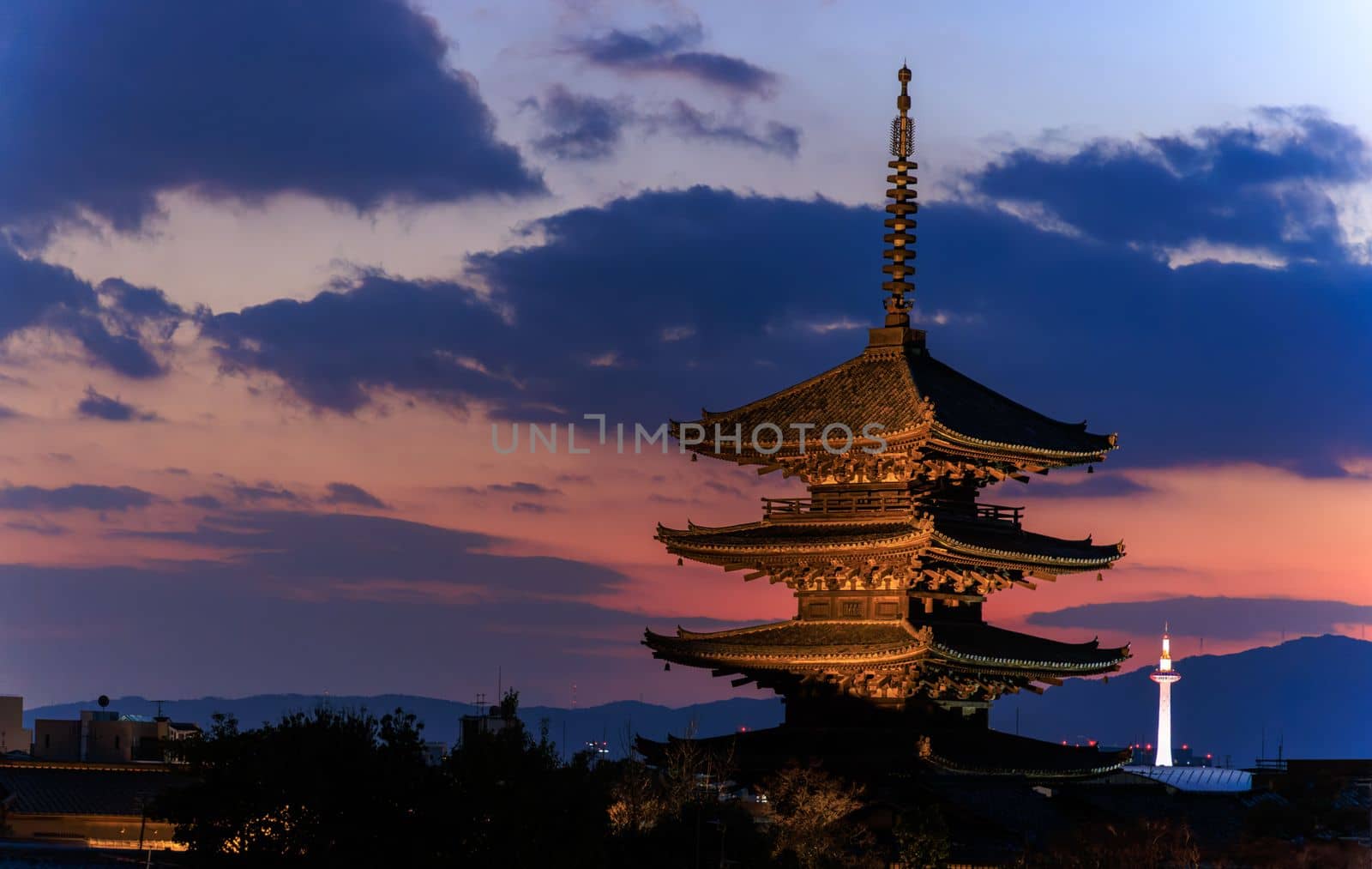 View from Higashiyama of Yasaka Pagoda and distant Kyoto Tower as sun sets. High quality photo