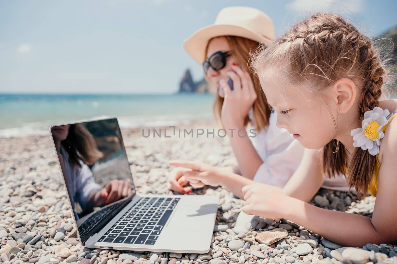 Woman sea laptop. Business woman with daughter, working on lapto by panophotograph