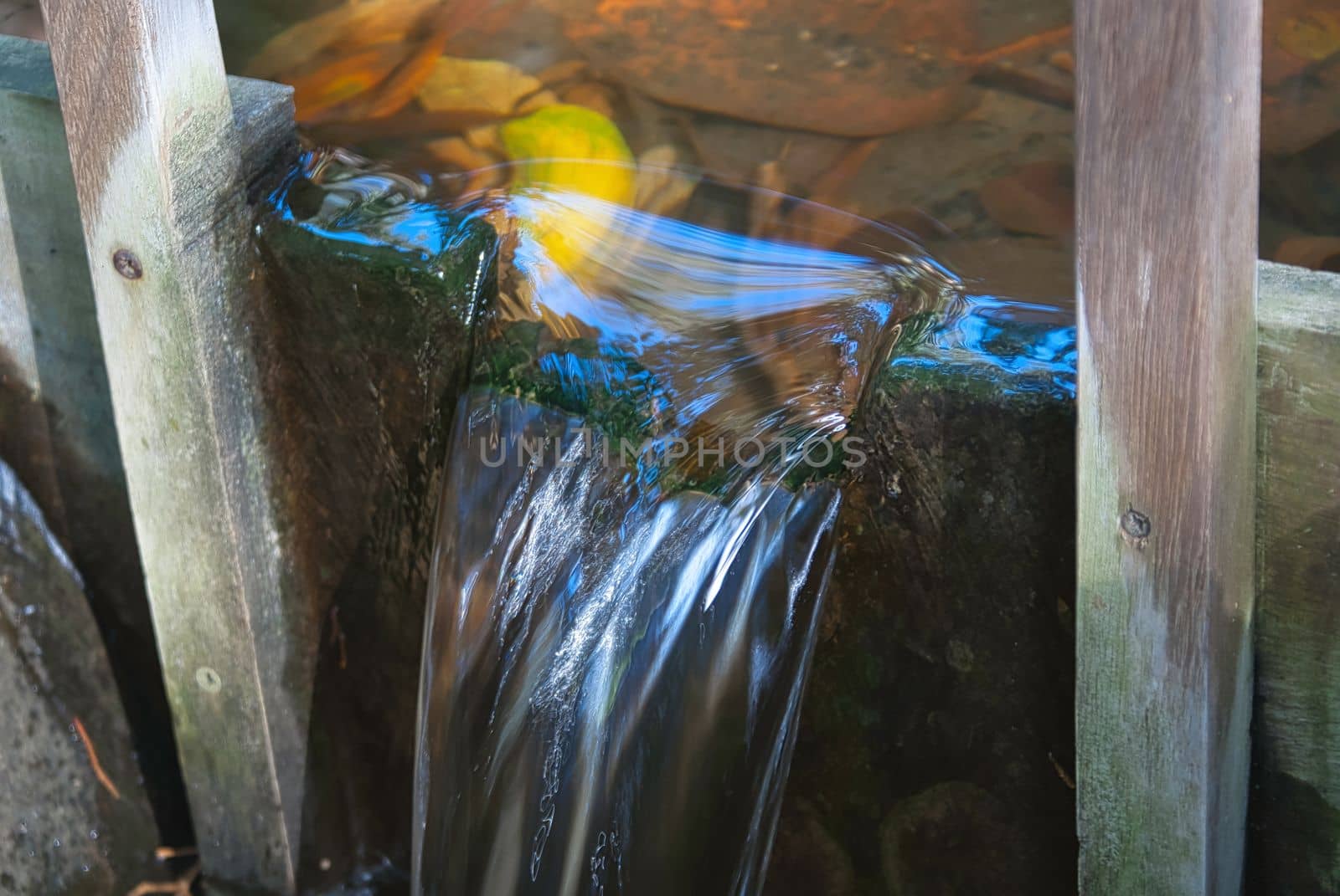 open wooden hatch with crystal clear water flowing out