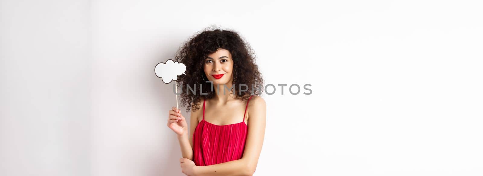 Elegant woman with curly hair, wearing red evening dress, holding cloud and smiling, standing on white background by Benzoix