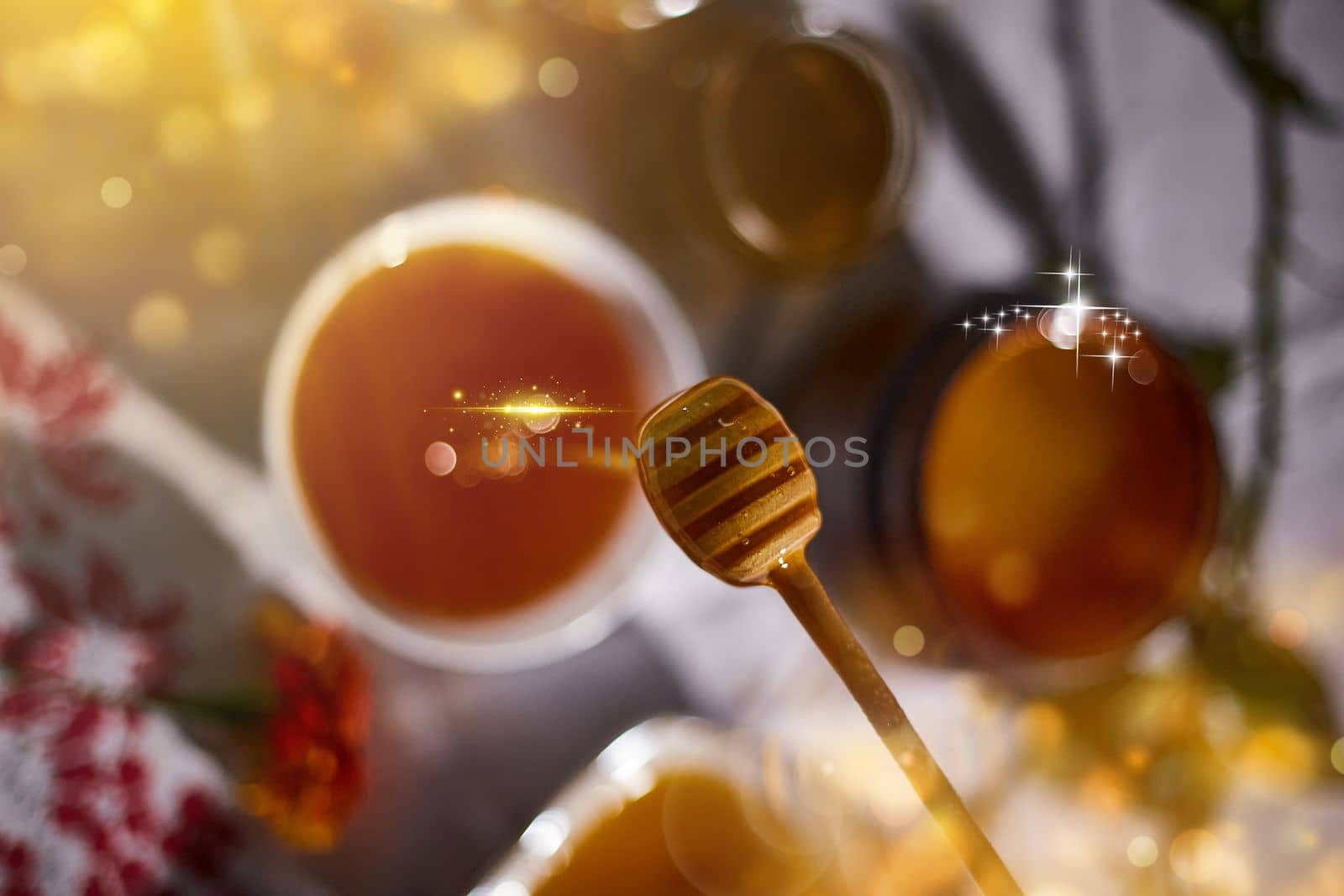 a jar of sweet honey on a table from the garden with apples in a glass