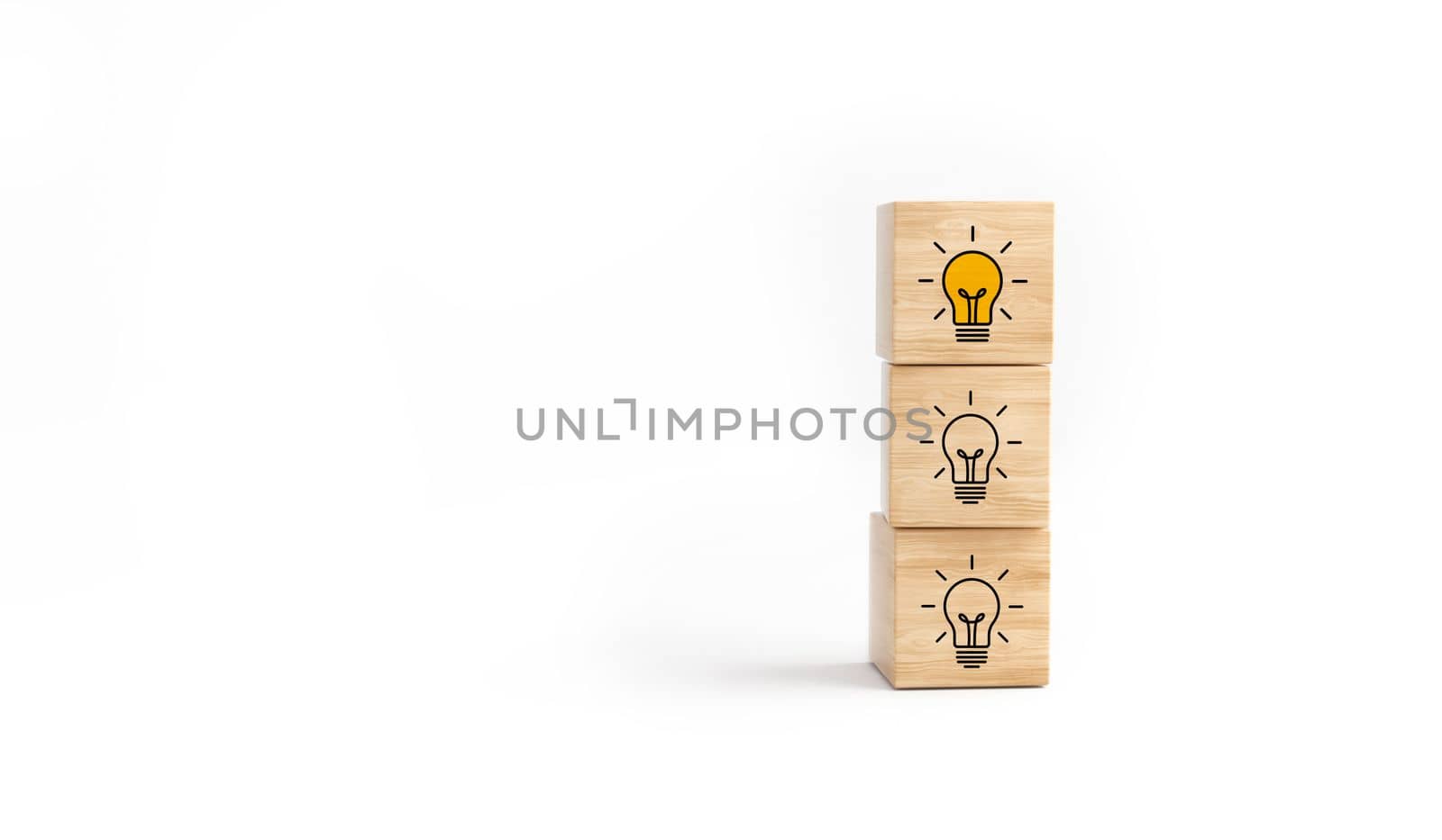 Wooden cube block tower with light bulb icon on white background. by ImagesRouges