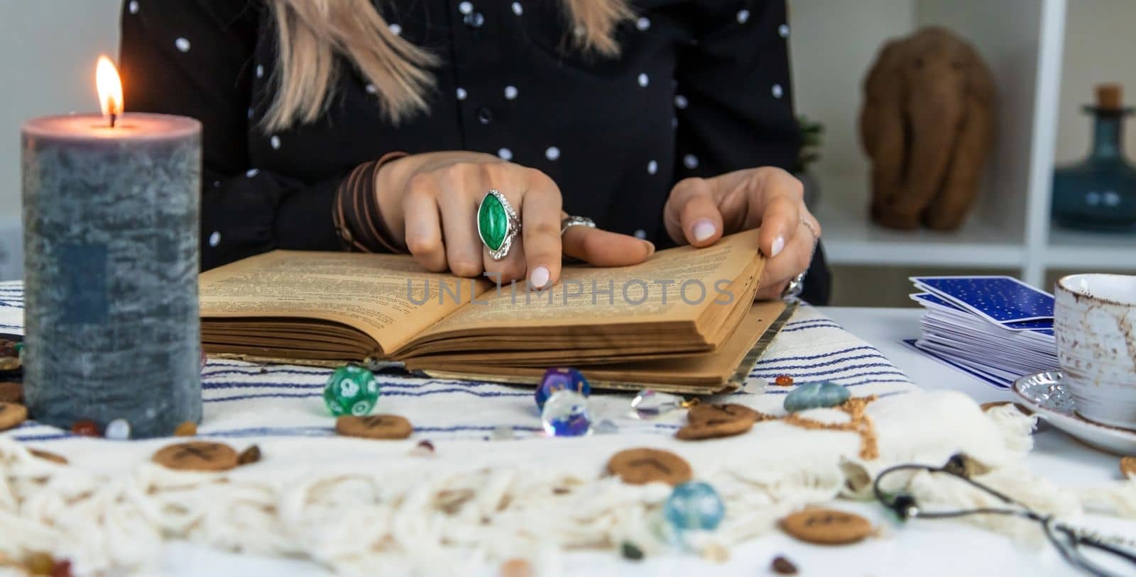 Woman fortune teller reads a book of spells. Selective focus. People.