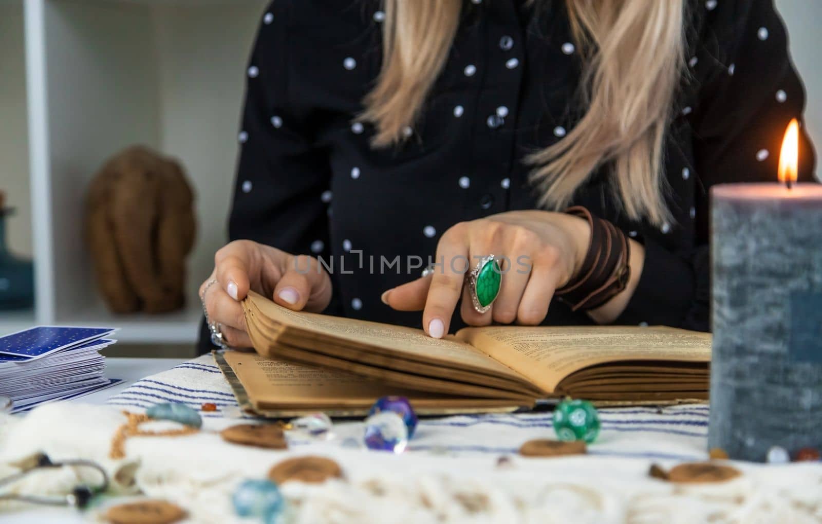 Woman fortune teller reads a book of spells. Selective focus. People.