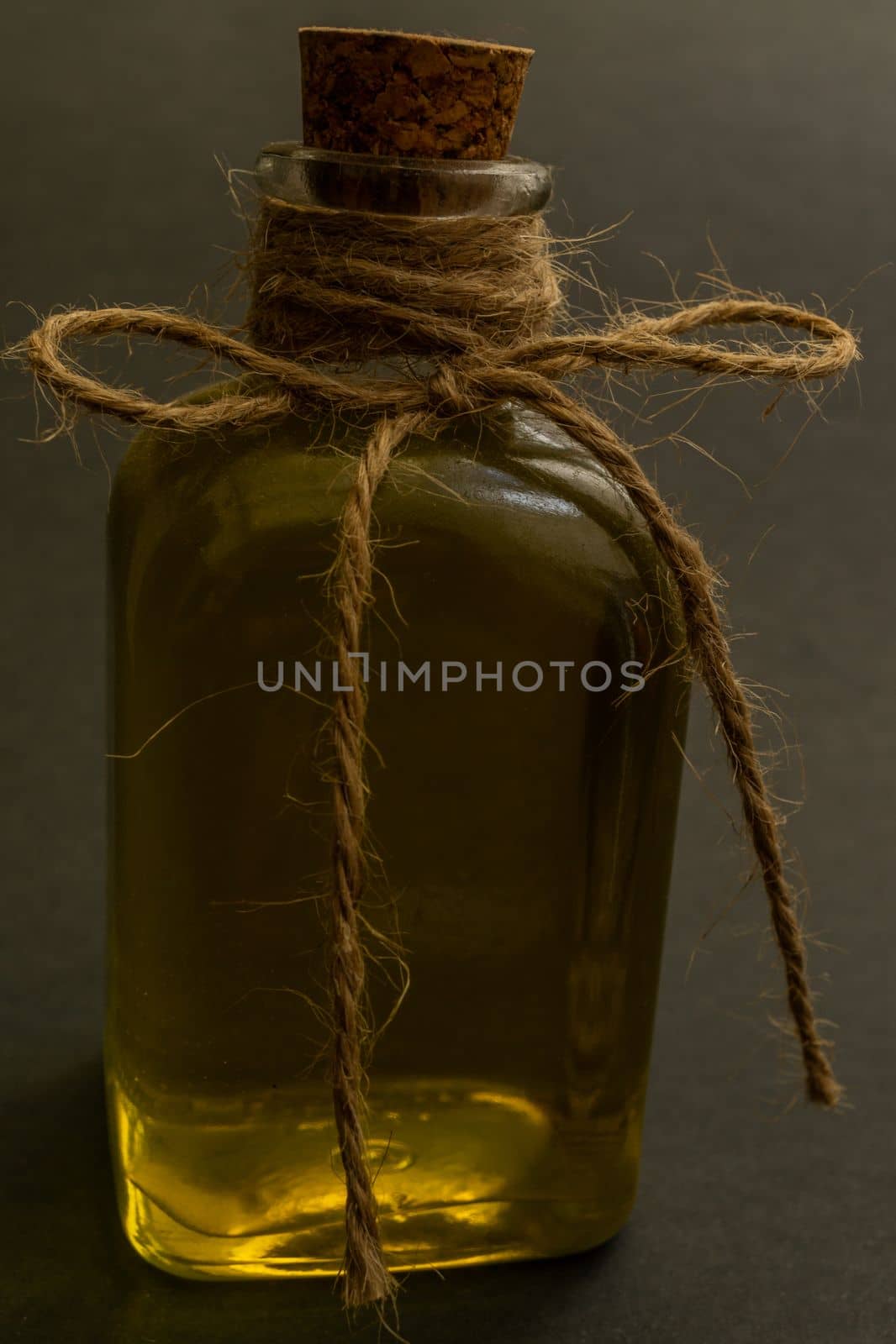 close-up of a glass bottle with cork stopper containing rosemary healing oil