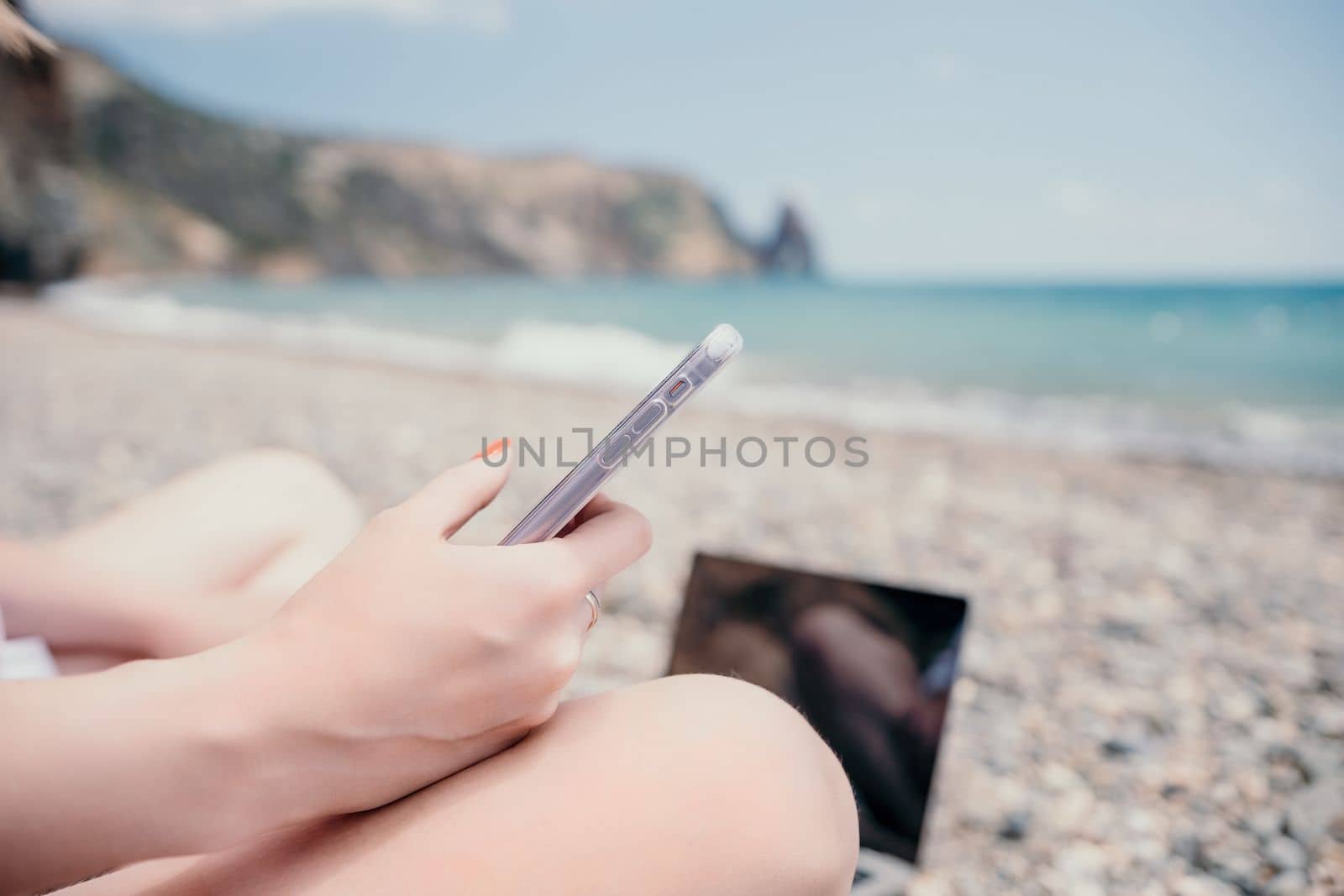 Woman sea laptop. Business woman working on laptop by sea at sun by panophotograph