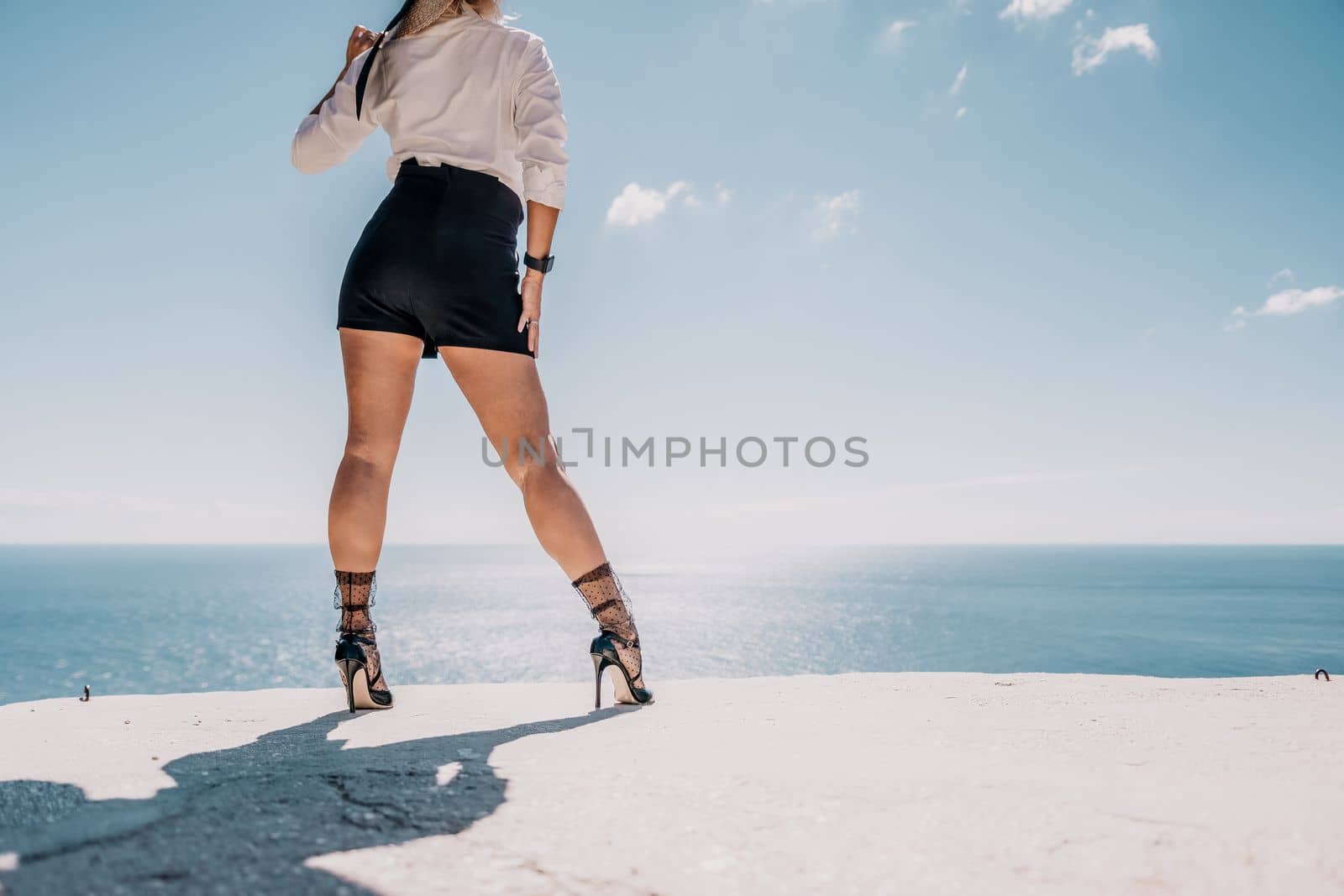 Woman sea hat. Business woman in yellow hat freelancer working over blue sea beach. Girl relieves stress from work. Freelance, digital nomad, travel and holidays concept by panophotograph