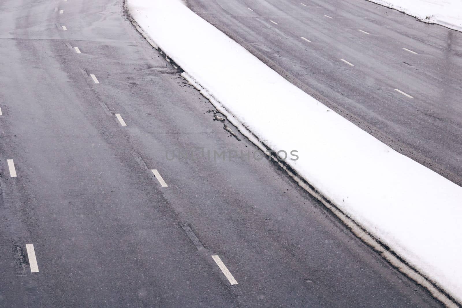 A wide road in the snow in winter close up