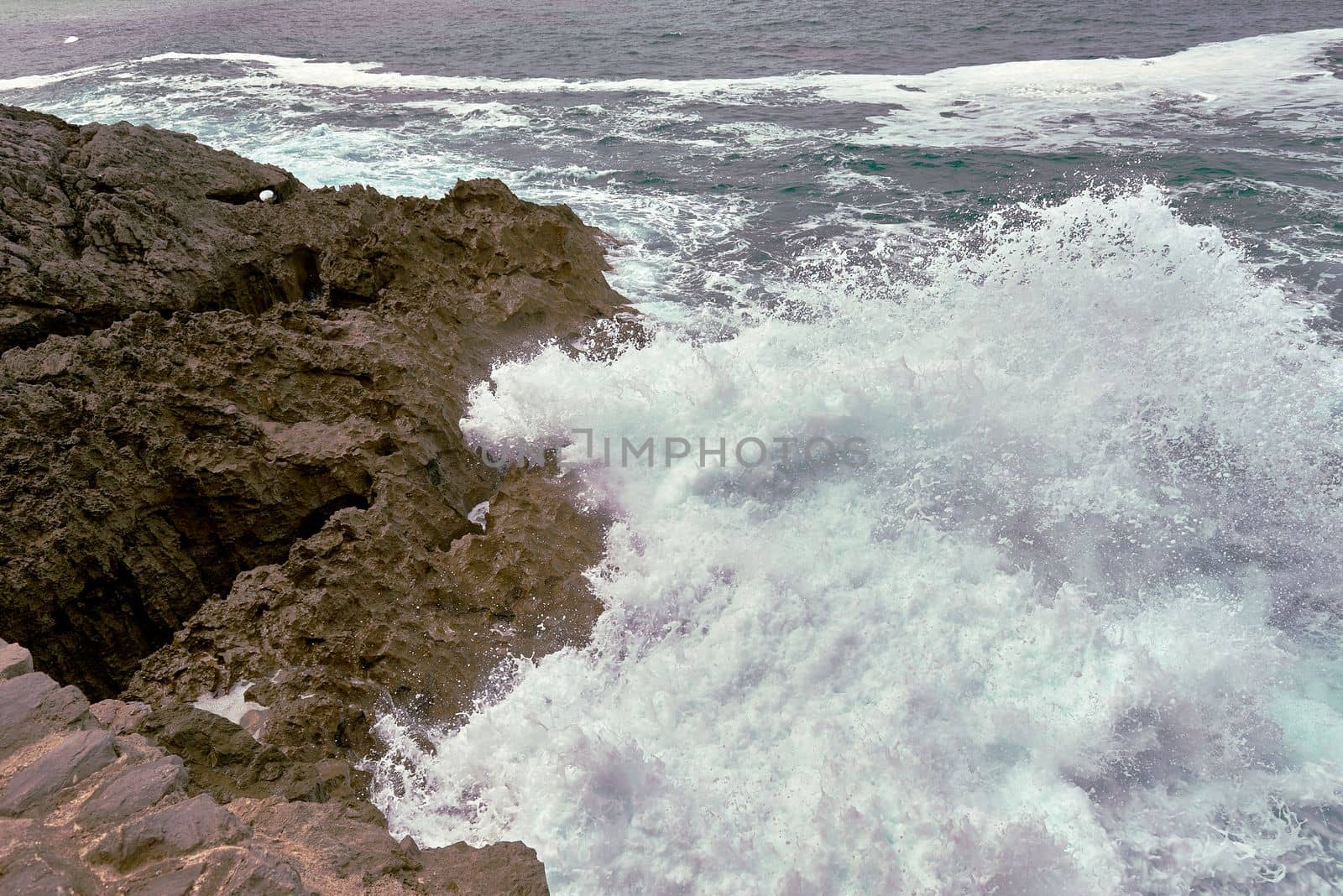 Waves breaking on the rocks at the shore of the beach by raul_ruiz