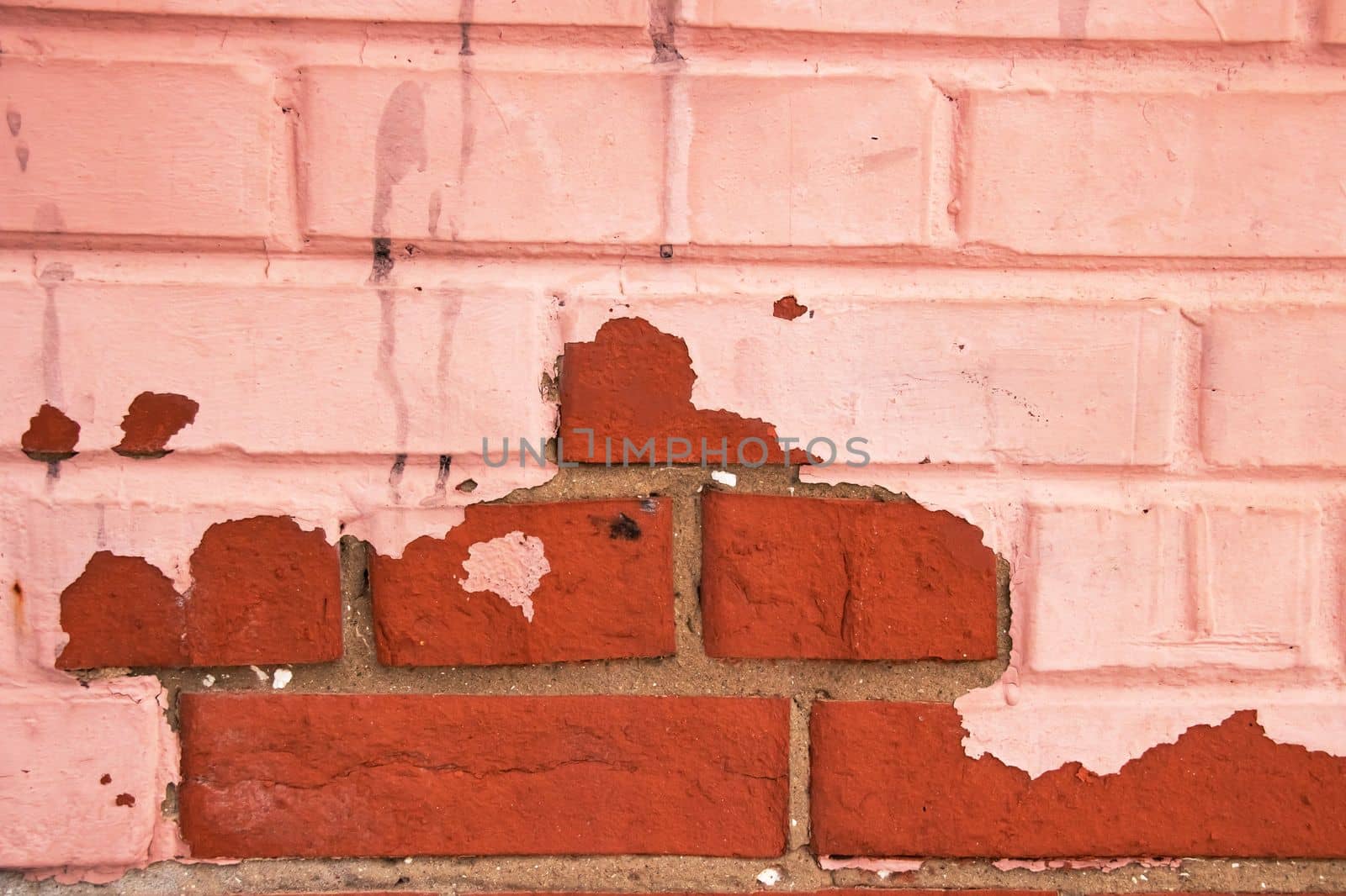 Peeling red paint on a brick wall, background or texture