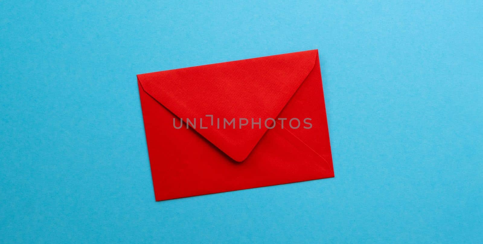 Red envelope isolated on blue background with copyspace. Concept of communication, delivery and correspondence. Old school contact post service