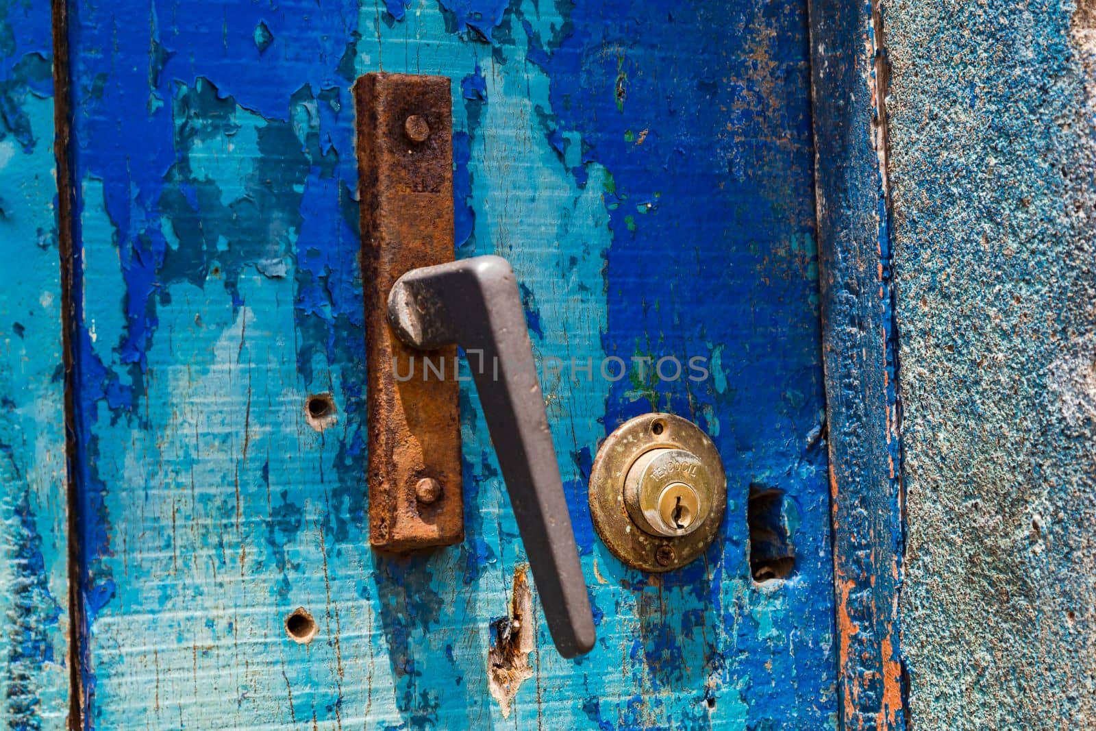 An old rusted doorknob with a lock on an old blue door, Cape Verde Islands, Africa