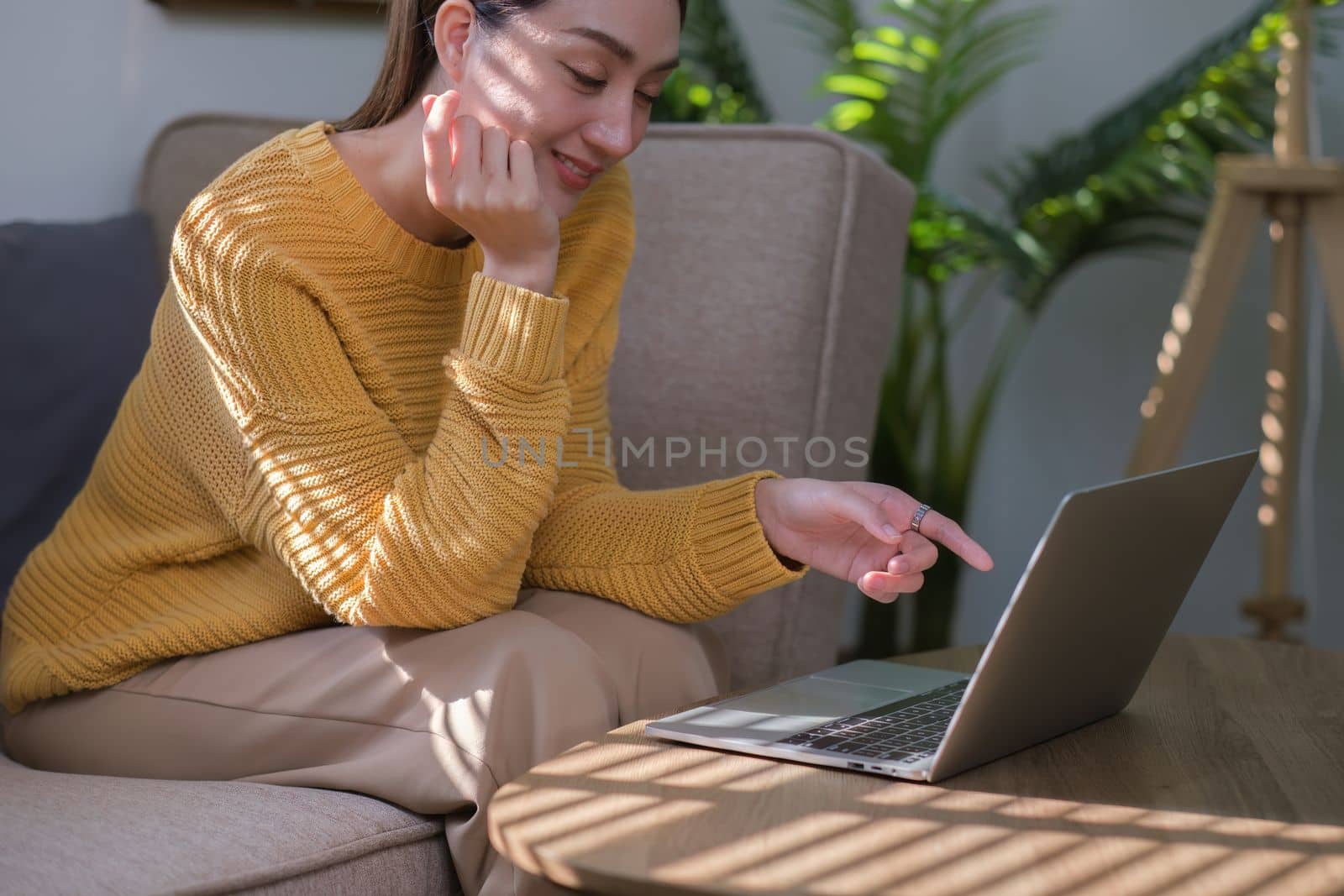 Portrait of Asian woman reading a e book on laptop after get up in morning. Morning lifestyle concept.