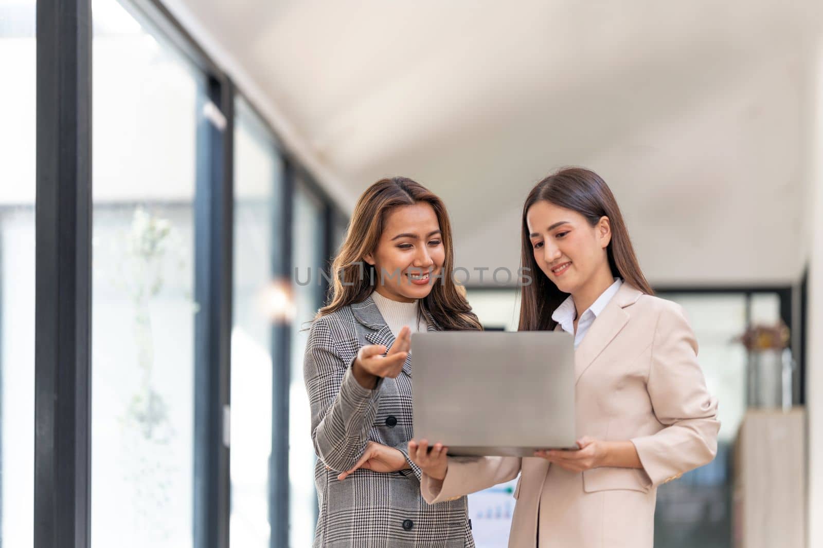 Young colleagues discuss business and analytical price charts using calculators and laptops to calculate financial, tax, accounting, statistics and analytical research.