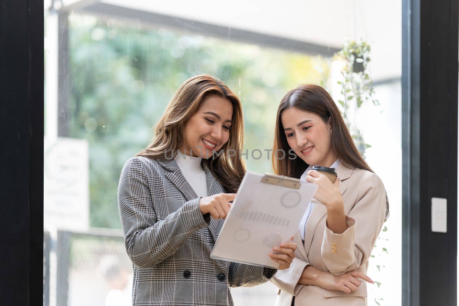 Young colleagues discuss business and analytical price charts using calculators and laptops to calculate financial, tax, accounting, statistics and analytical research.