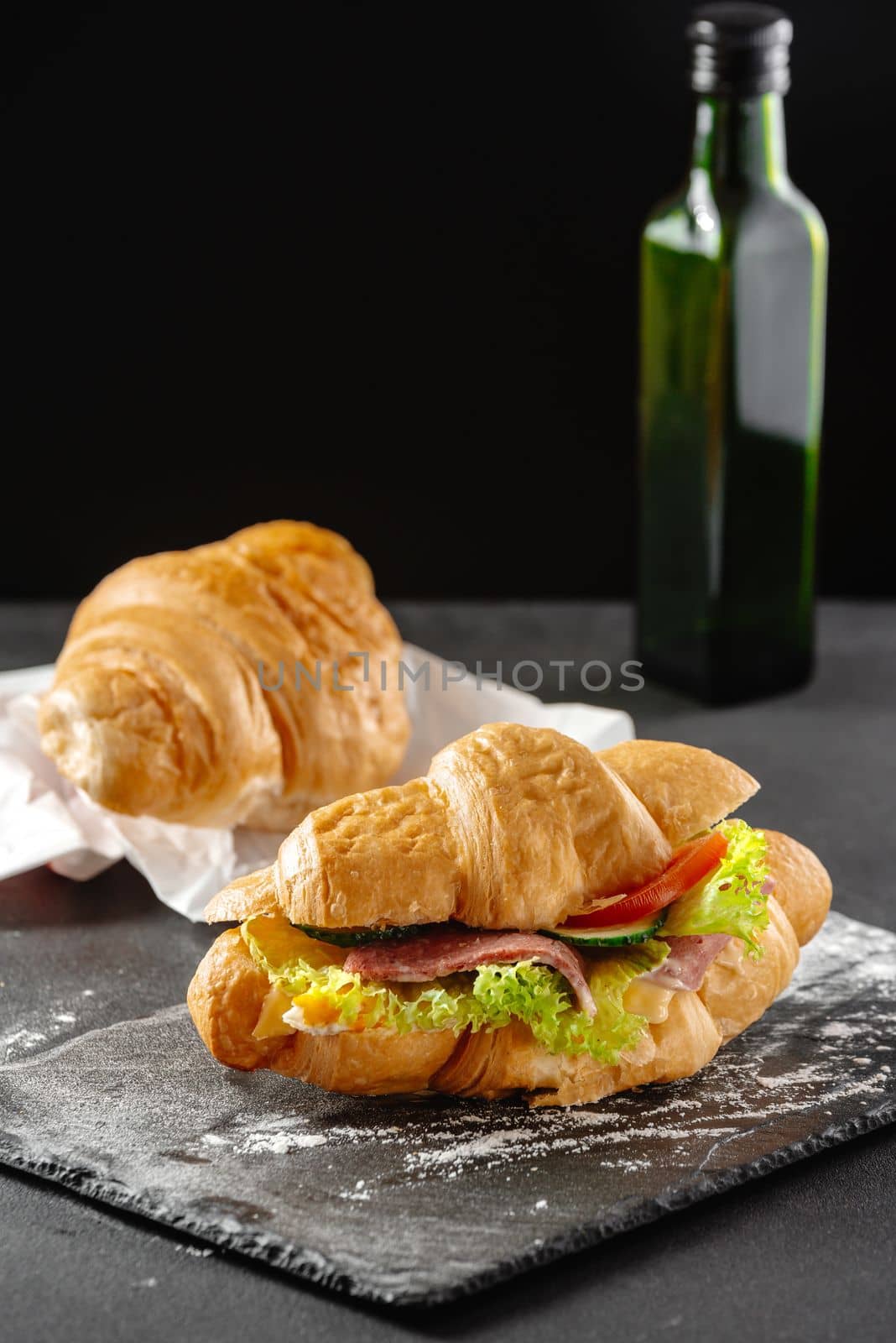 Delicious breakfast. Big croissant sandwich with sausage, cheese and tomato.