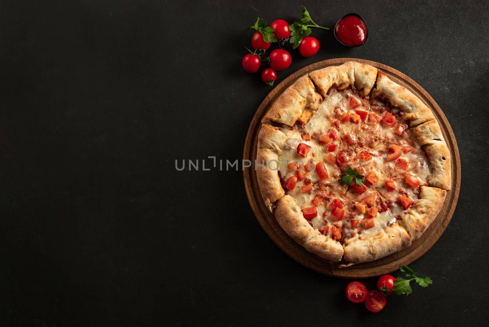 Neapolitan pizza with spices, tomatoes and mozzarella cheese on a dark background. Margarita pizza with mozzarella, tomato sauce, spinach on thick dough. Top view. Copy space.