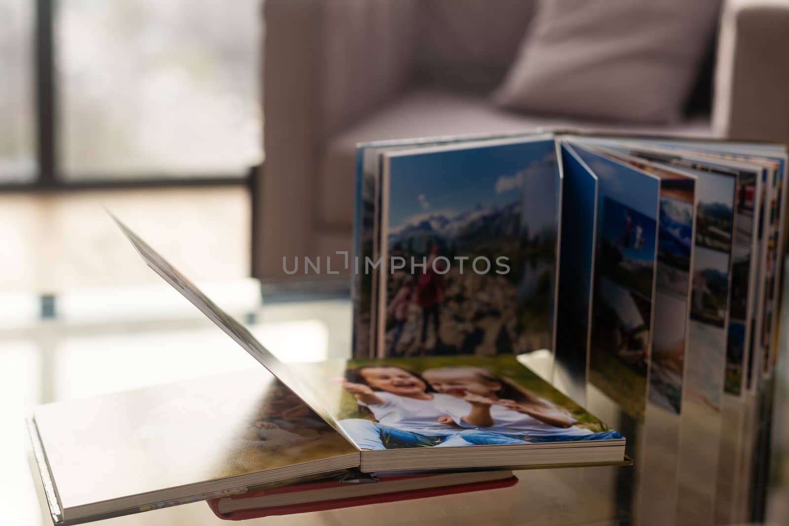 on table open photobook from photo shoot of family. preservation of important moments of life in photo album. result of work of photographer and designer. polygraphy. by Andelov13