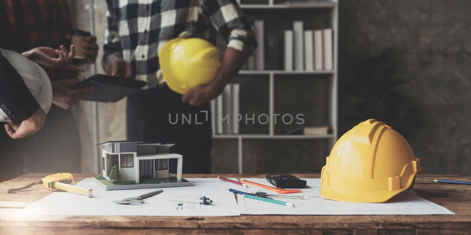 Civil engineer teams meeting working together wear worker helmets hardhat on construction site in modern city. Foreman industry project manager engineer teamwork. Asian industry professional team...