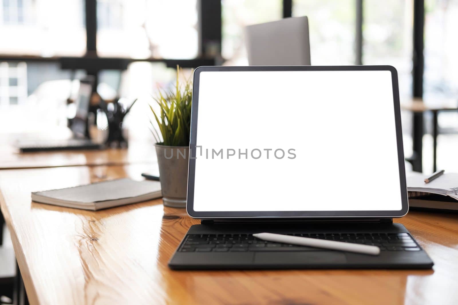 Photo of computer laptop with white blank screen putting on the modern working table with blurred comfortable office as background. Void screen for advertise concept. by wichayada