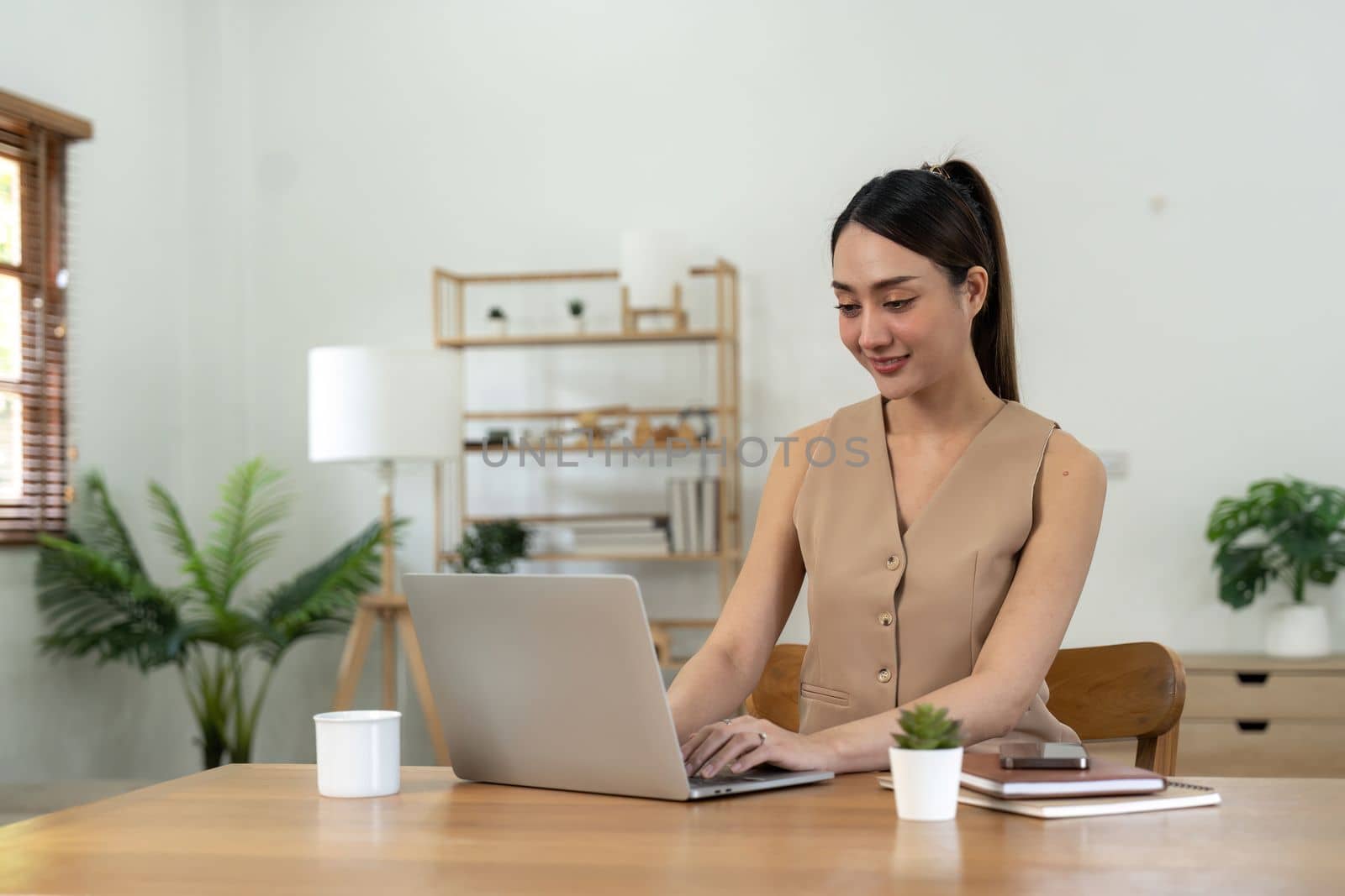 Happy Asian woman using laptop at home