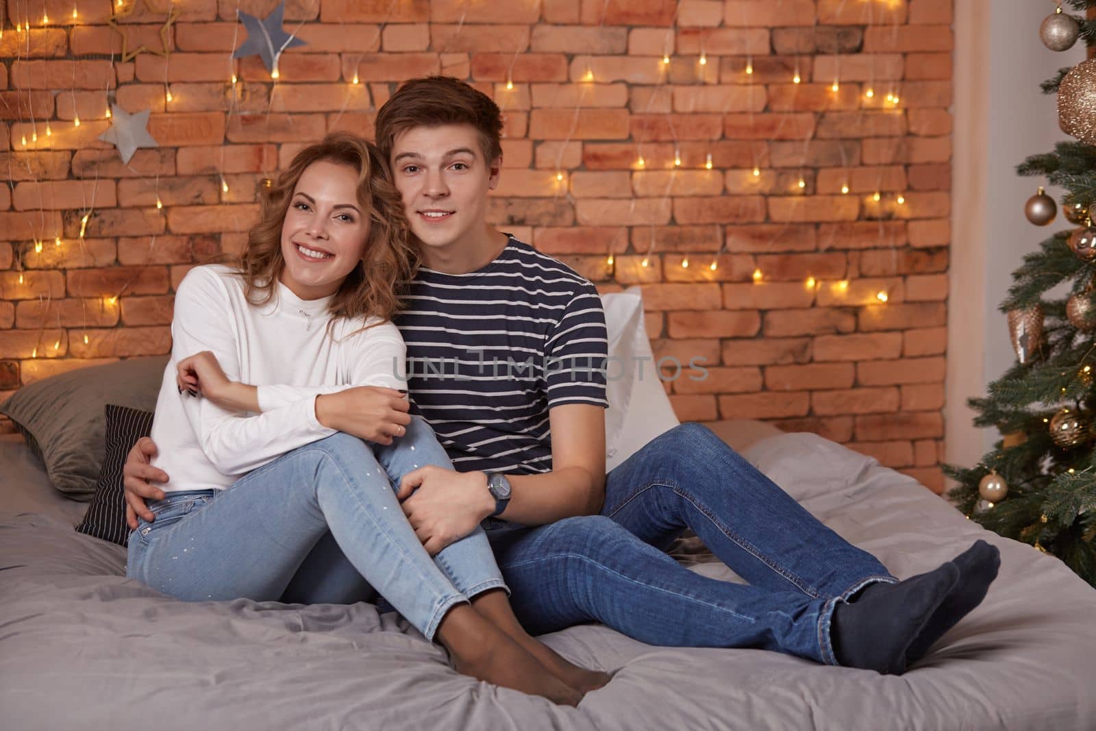 Young man and woman tenderly embracing in bedroom on the bed by nazarovsergey