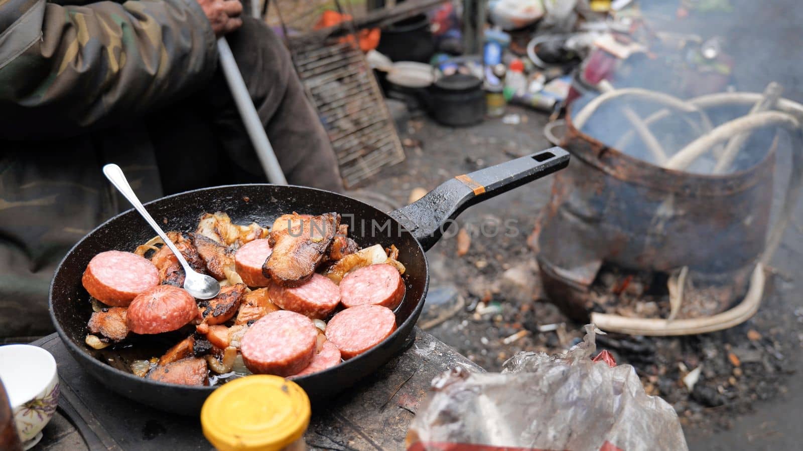 Homeless people fry food in the woods near the landfill