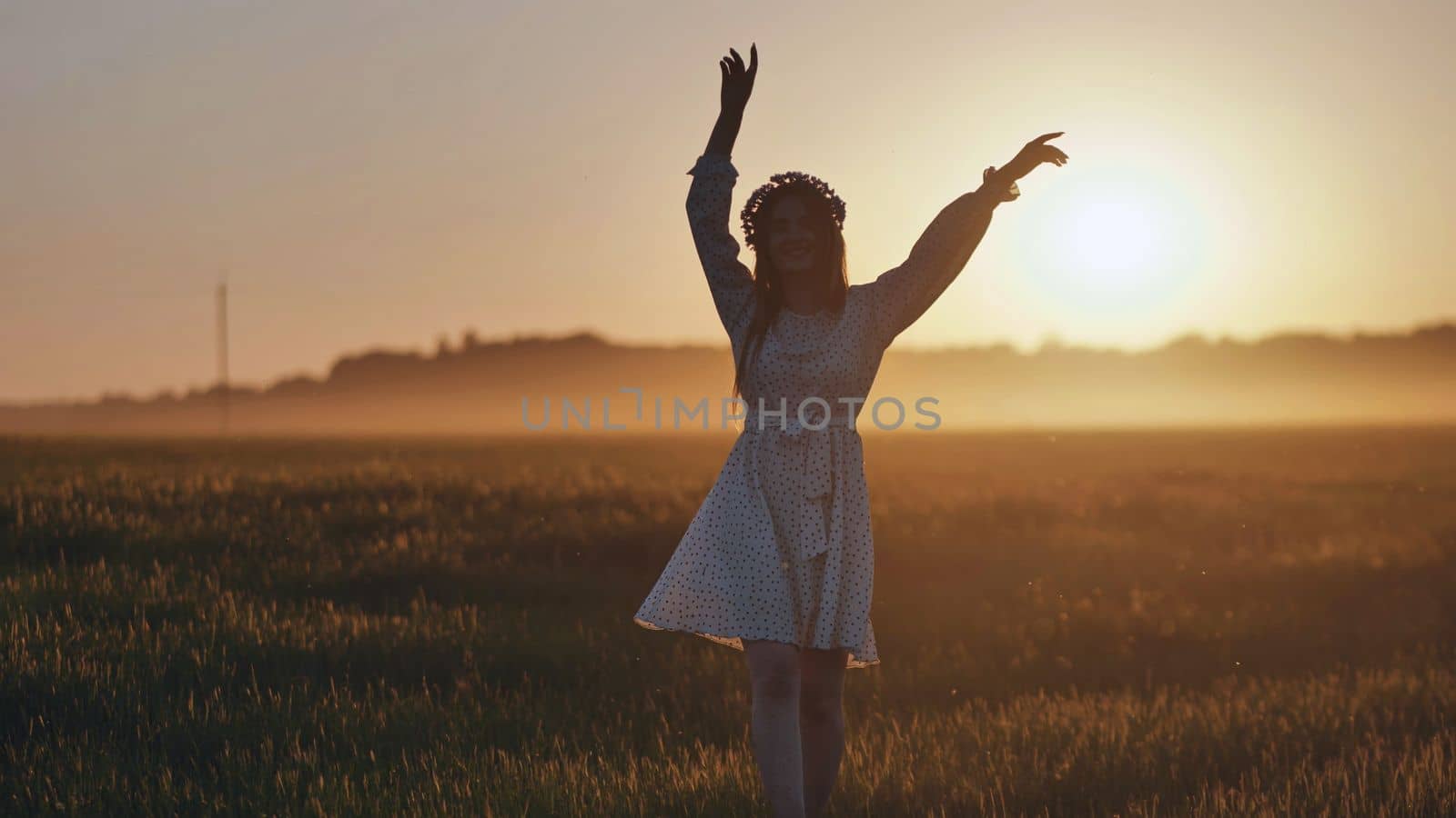 A silhouette of a young Ukrainian girl circling at sunset in the summer