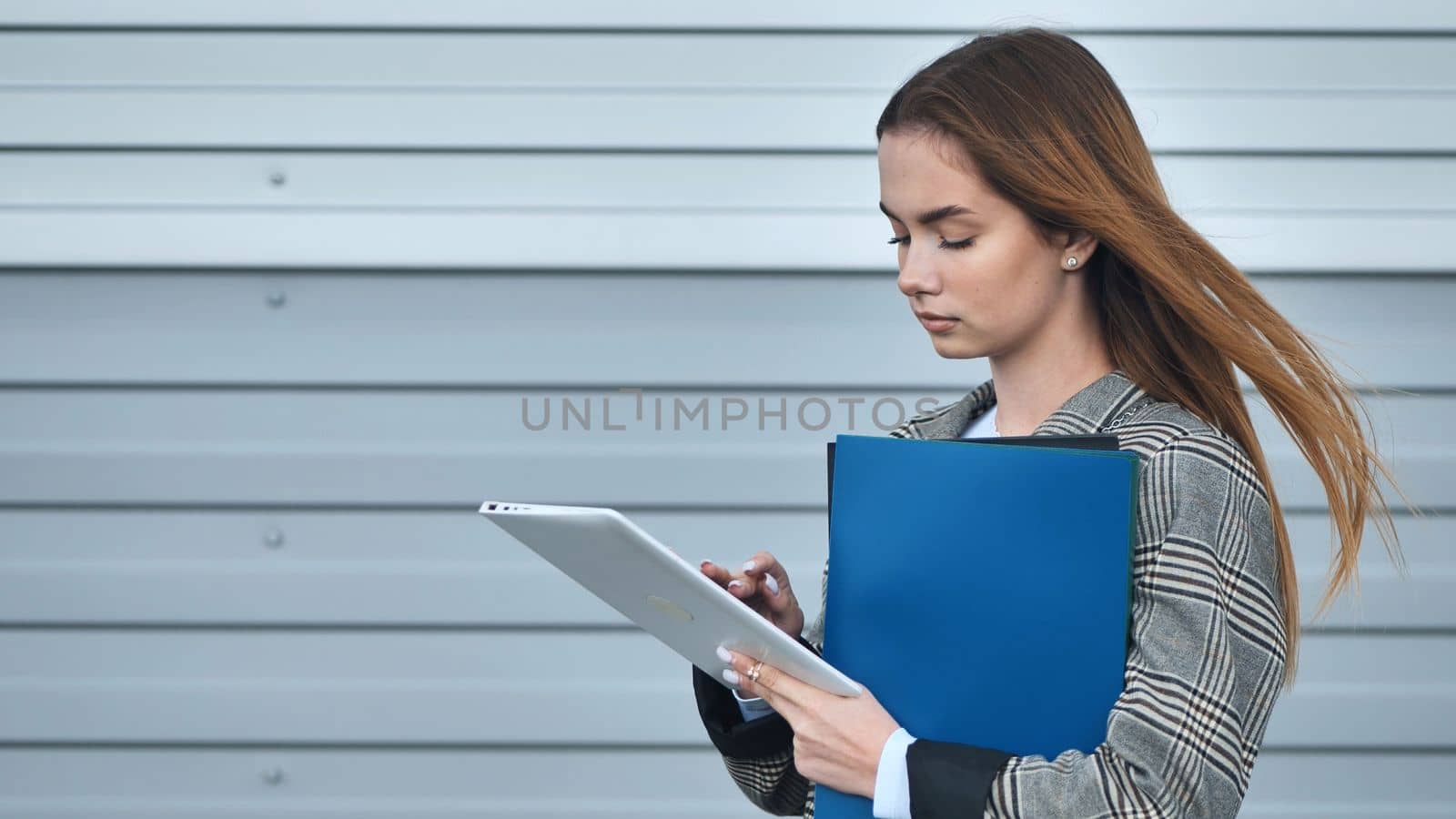 A young student works with a tablet and a phone
