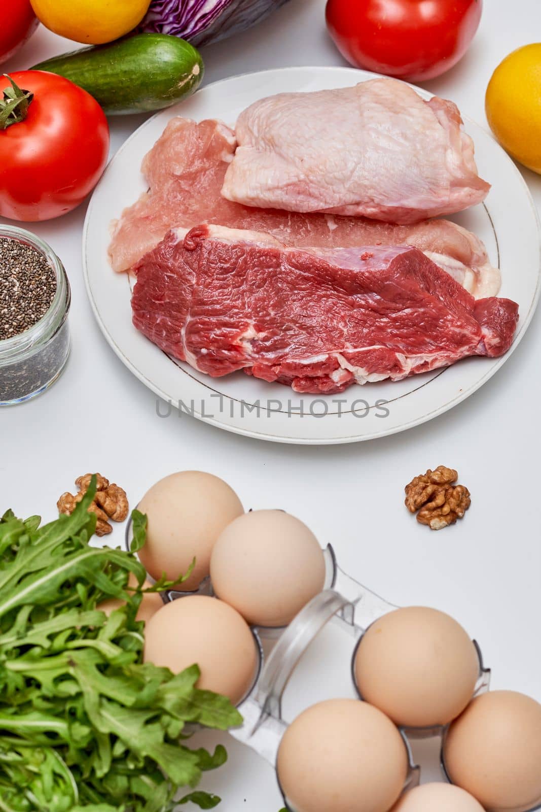 a table with meat eggs and vegetables on it by golibtolibov