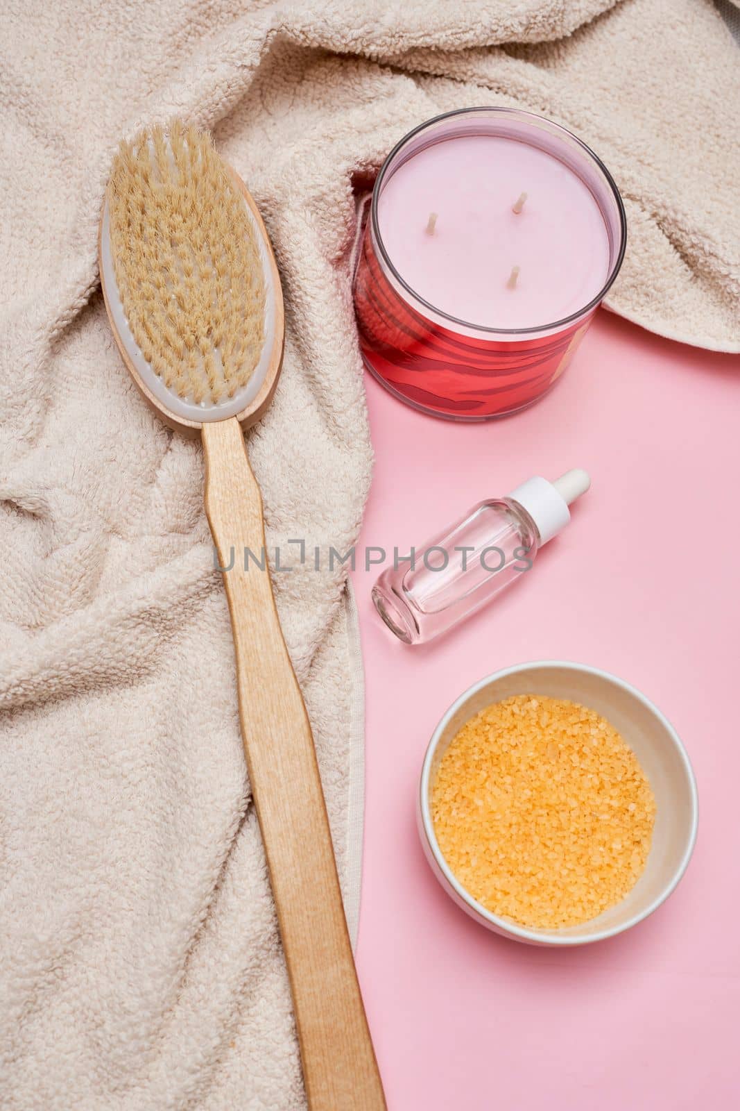 the contents of a hairbrush, bowl and brush on a pink surface with a white towel next to it
