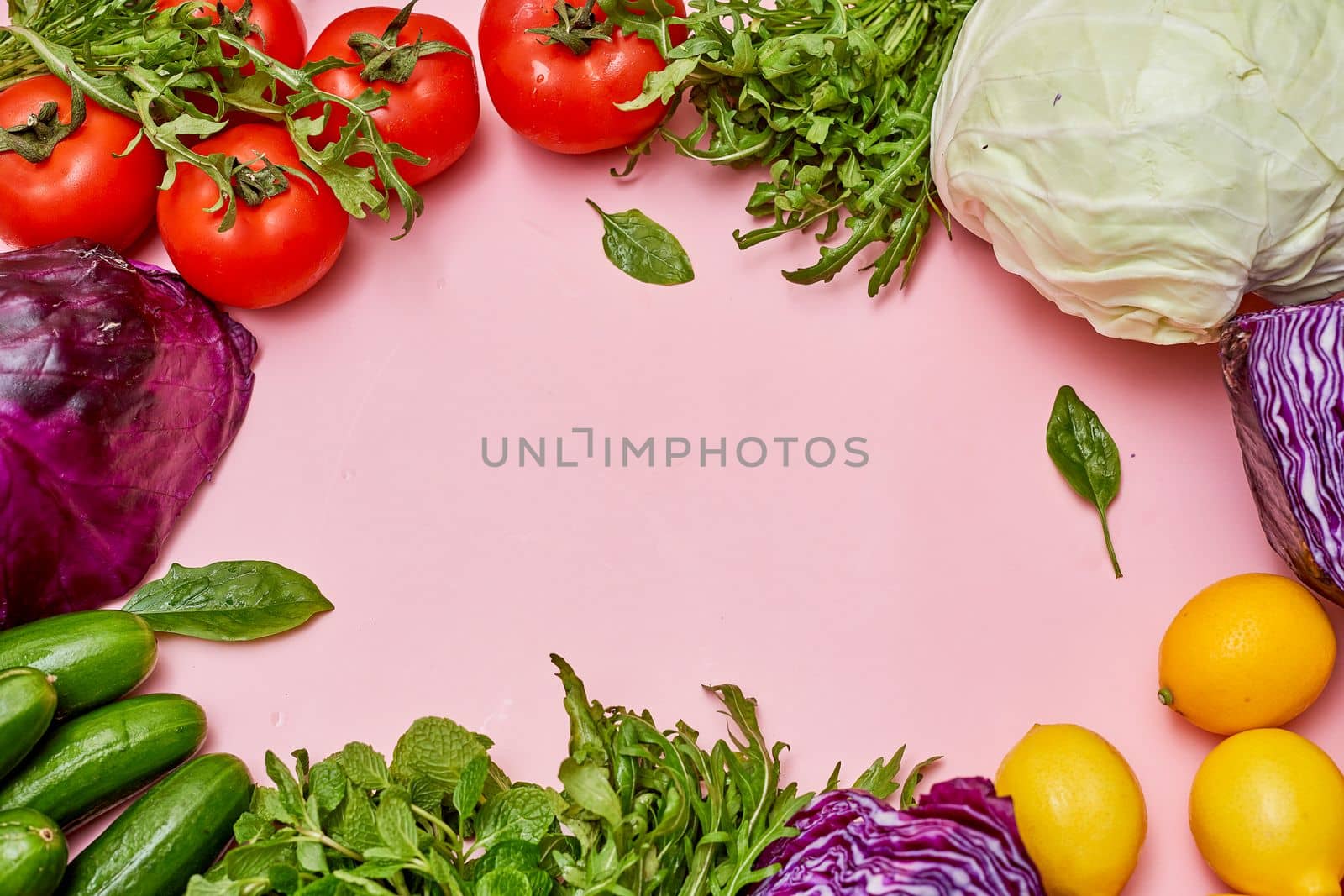 a circle of fresh vegetables on a pink background by golibtolibov